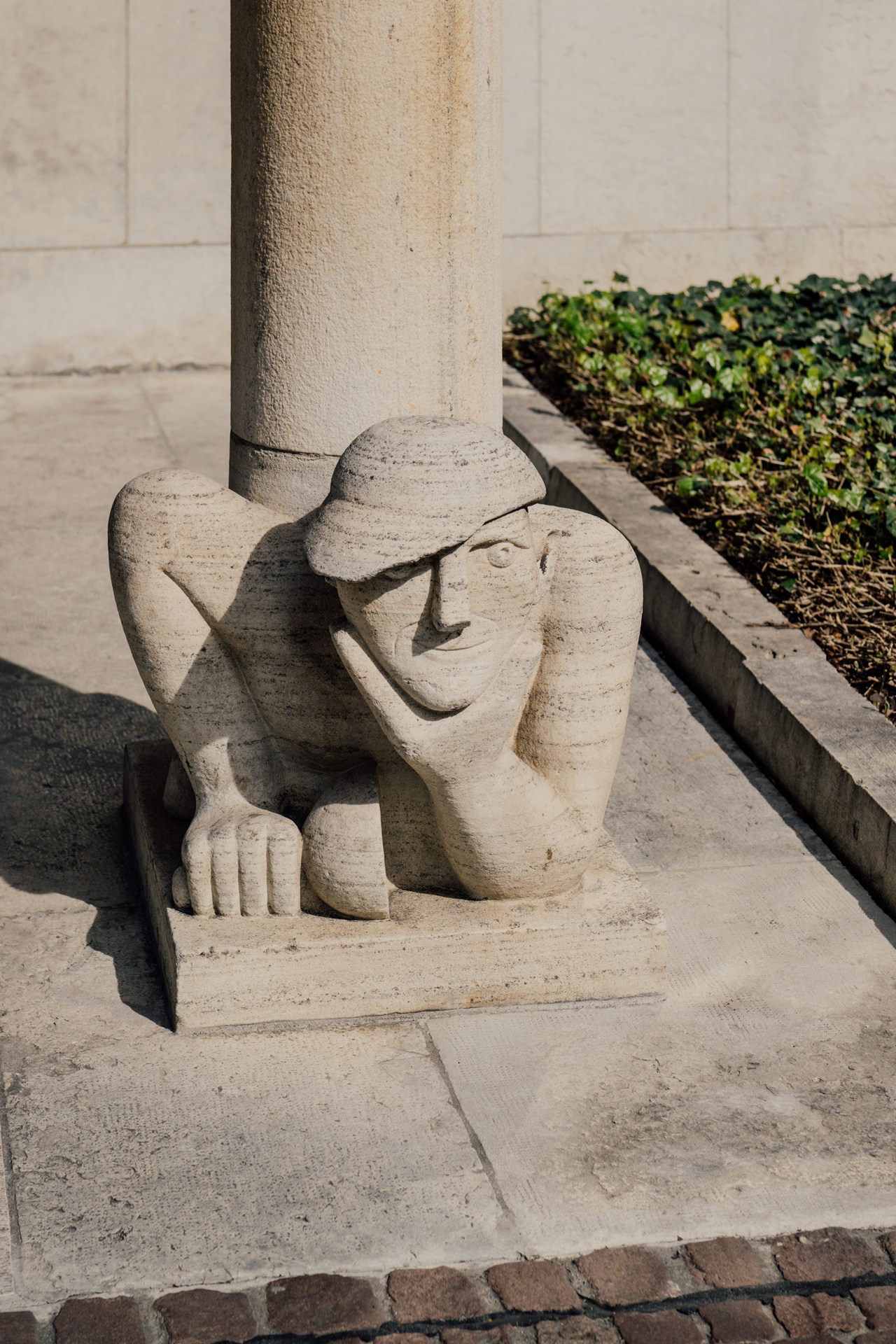 Stone carved sculpture of a figure at the base of a column in Basel