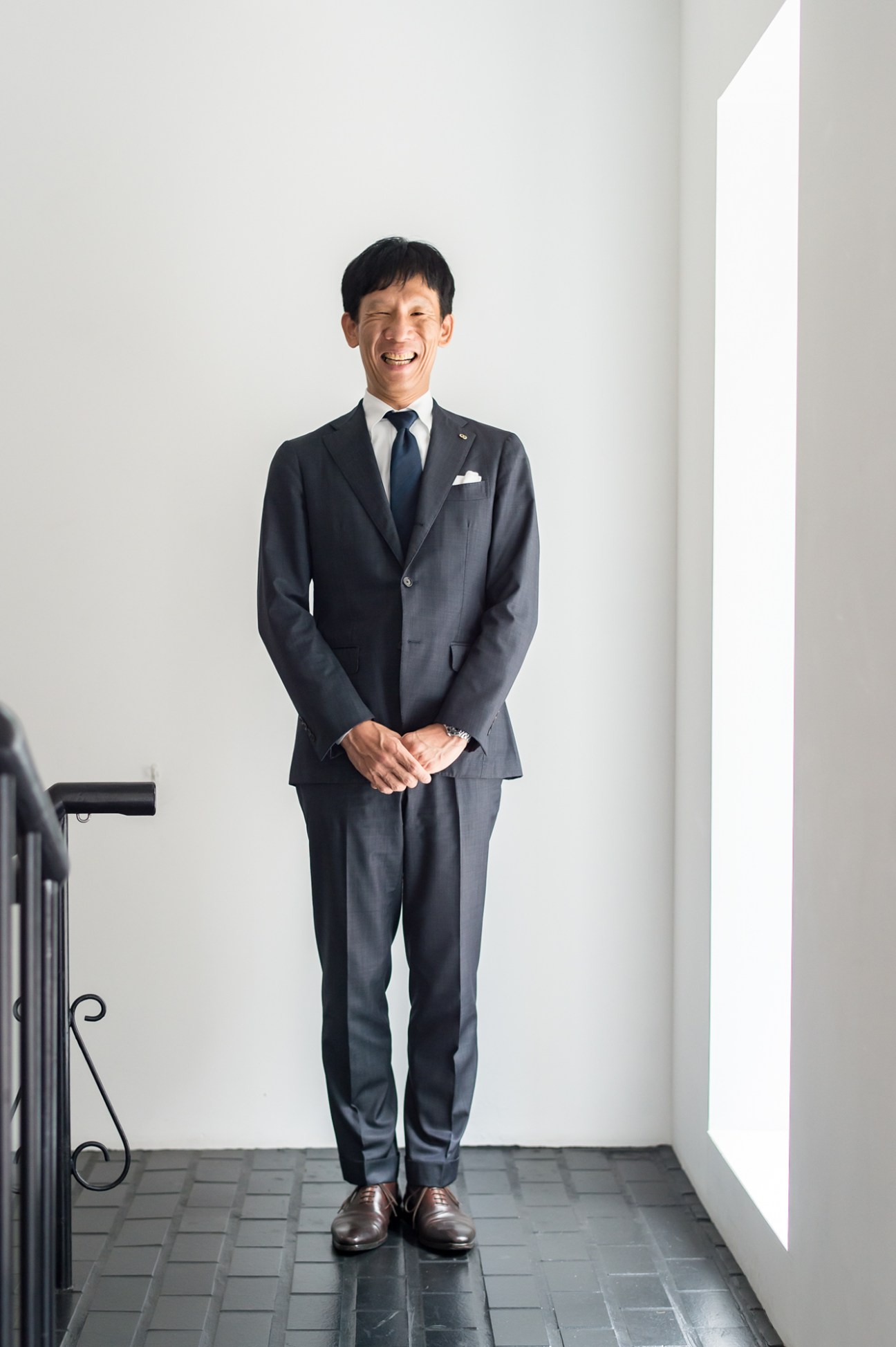 Takeshi Yamanaka, president of Maruni, sitting in the company's Japanese workshop surrounded by wooden furniture pieces