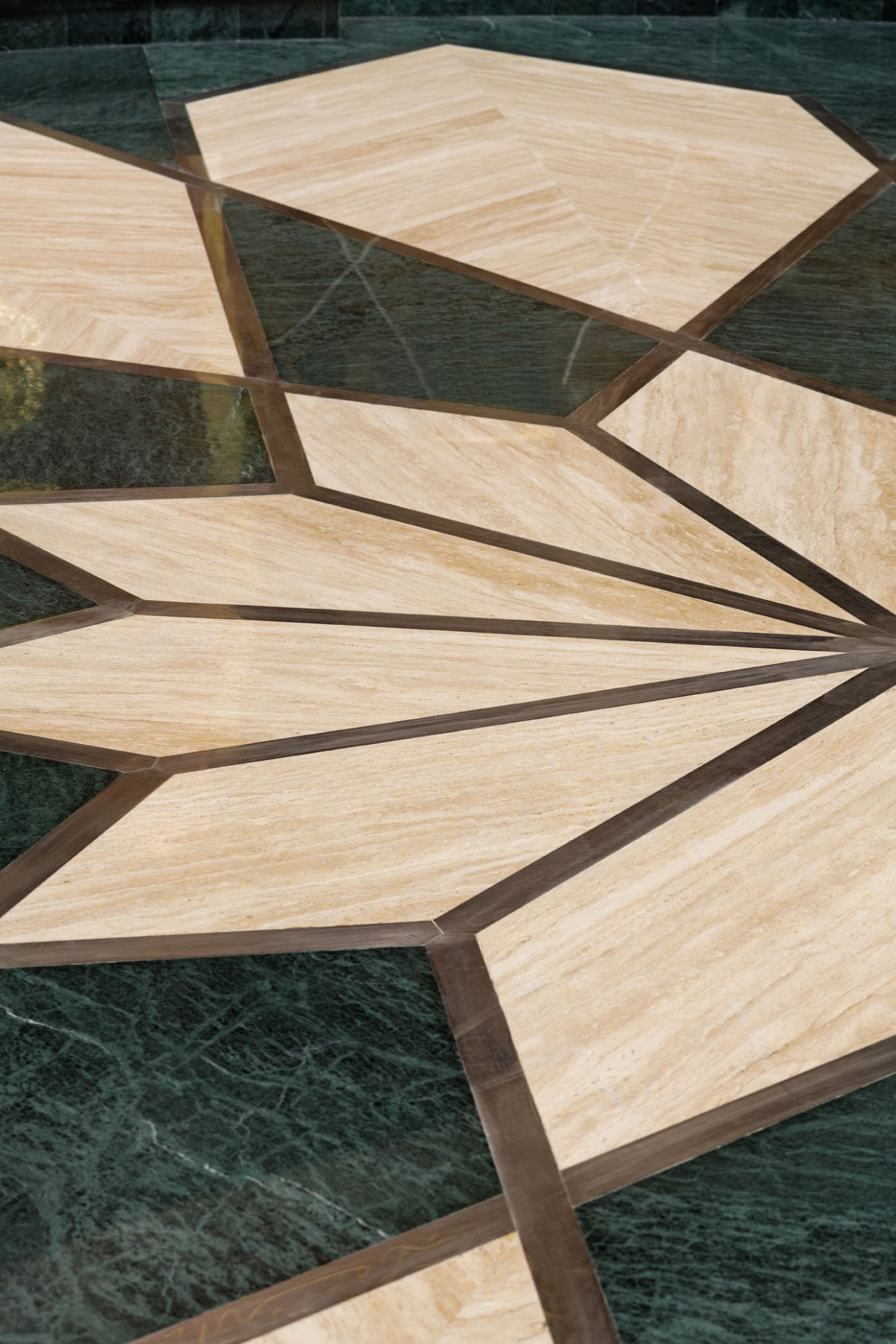 Close-up detail of geometric rhombus pattern carved into travertine center circle floor
