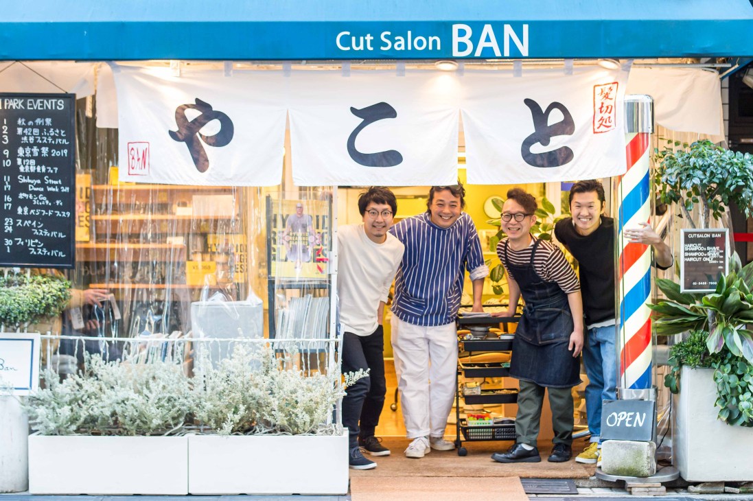 Cut Salon Ban owner Tsutomu Nagai standing with his three staff members inside their Tokyo barbershop