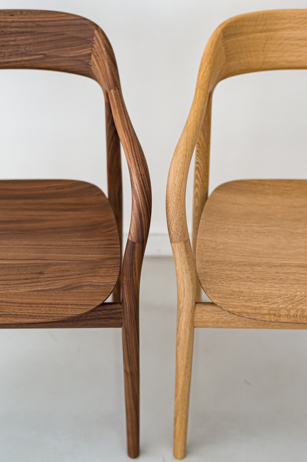 Tako chair by Naoto Fukasawa showing the curved wooden form and smooth arms in natural wood finish