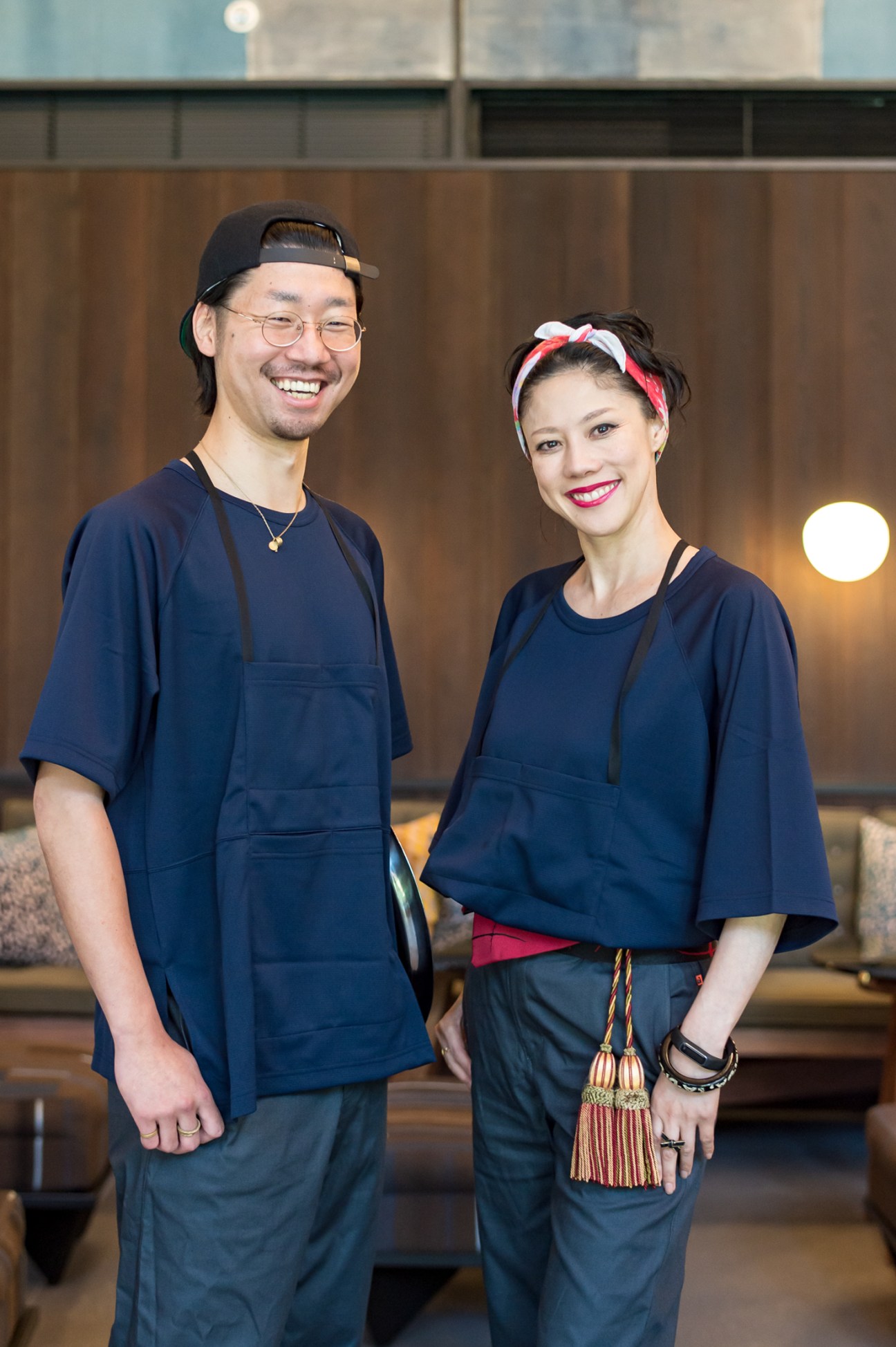 Two staff members in navy uniforms smiling at Piopiko cocktail bar and taco lounge