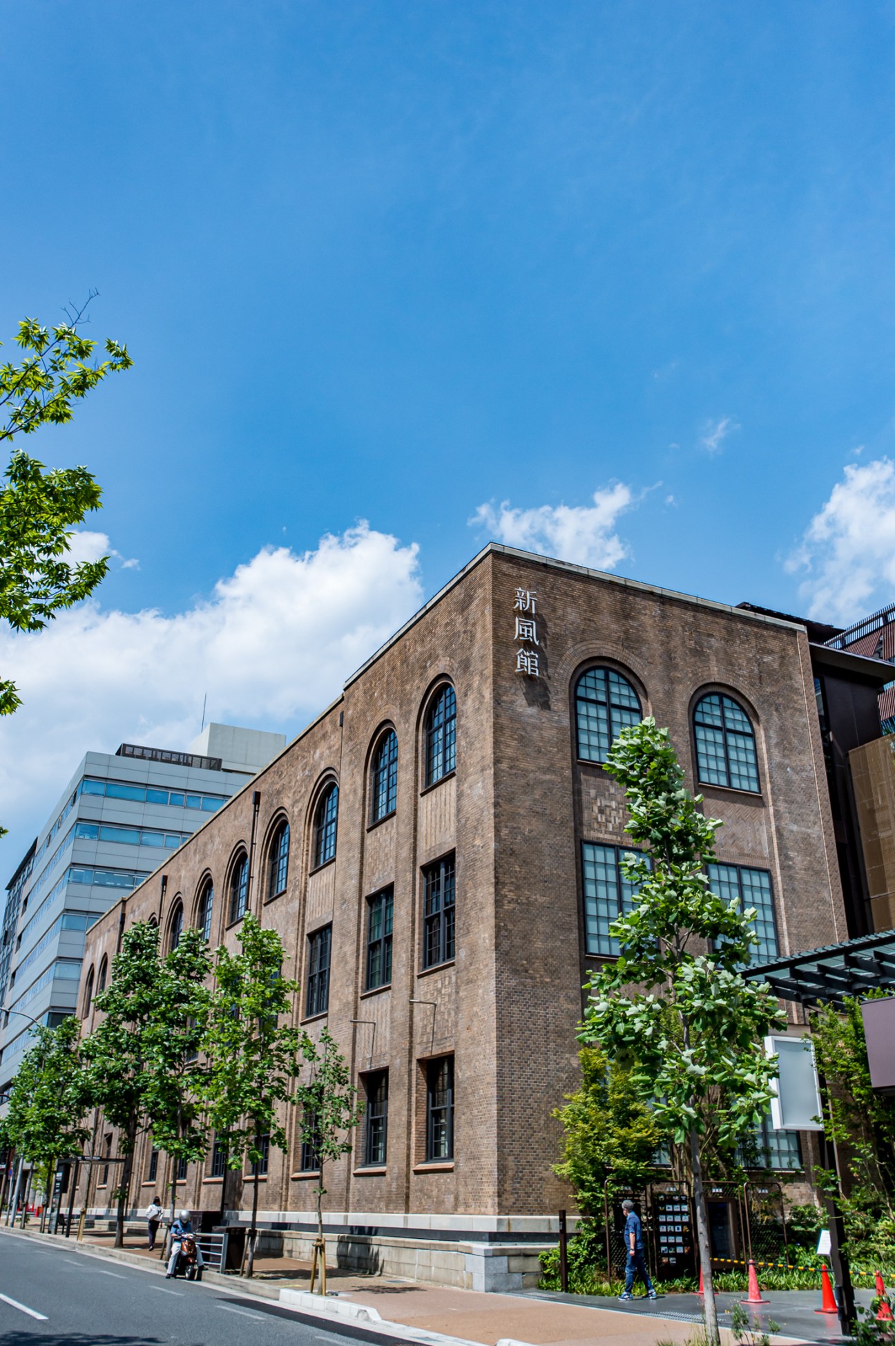 Brick facade of the historic Shimpukan building with arched windows and Japanese characters on the exterior