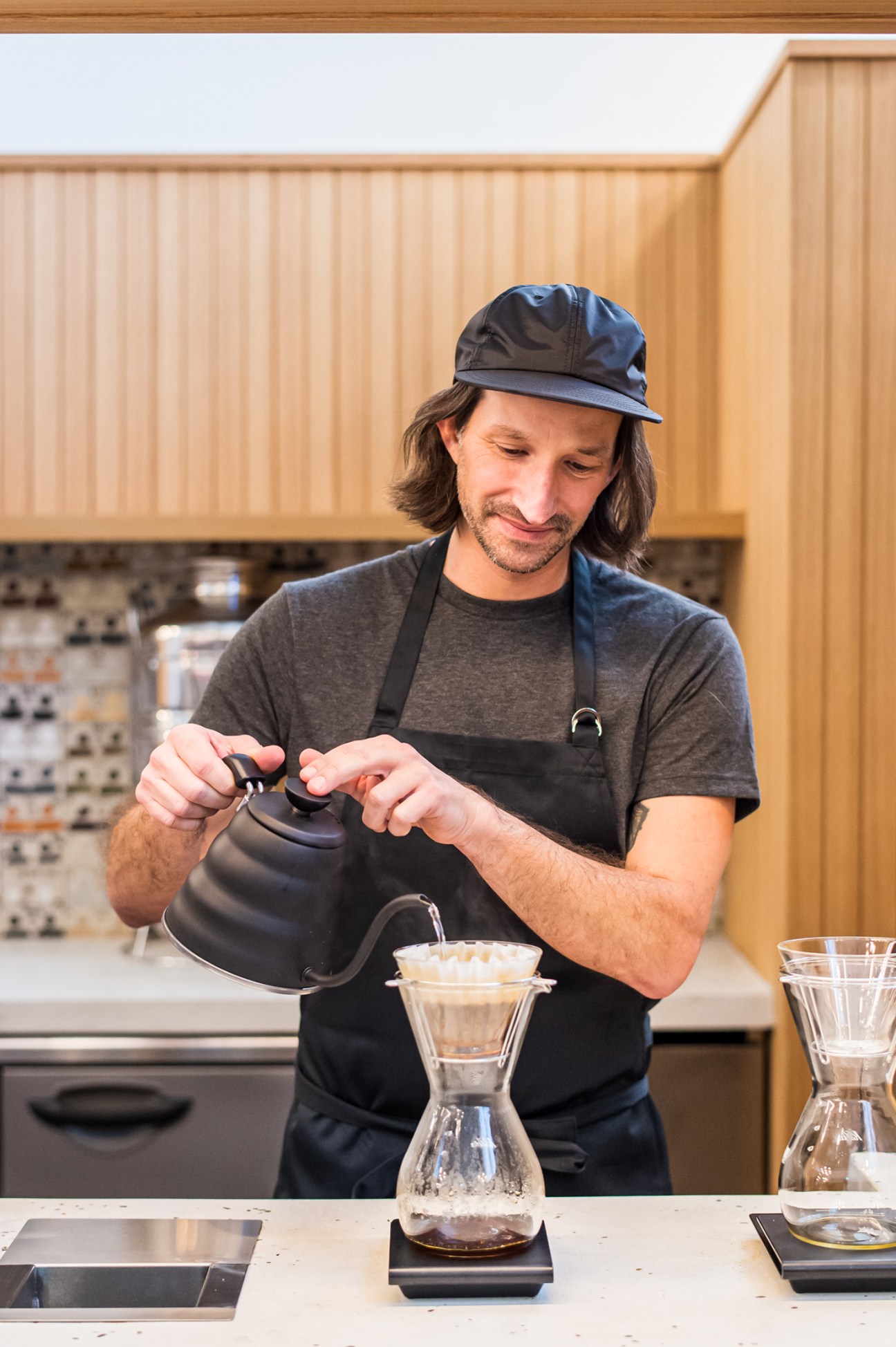 Andrew Curry from Stumptown café pouring hot water from a gooseneck kettle into a pour-over coffee dripper