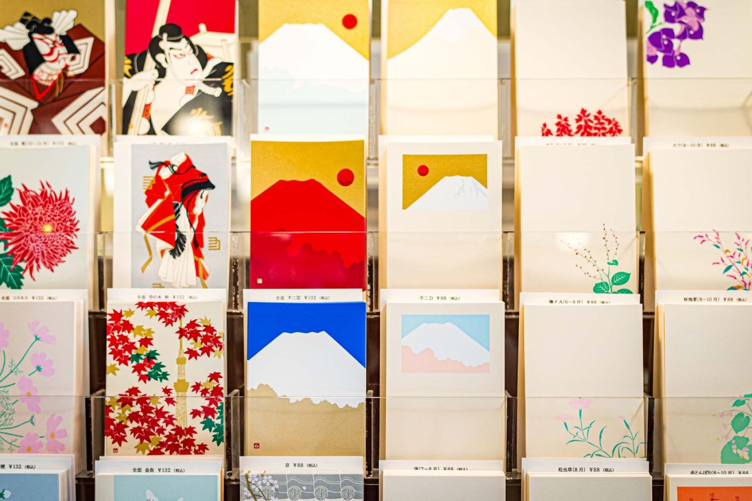 Display of seasonal silkscreen-printed postcards featuring stylized Japanese landscapes at Kyukyodo