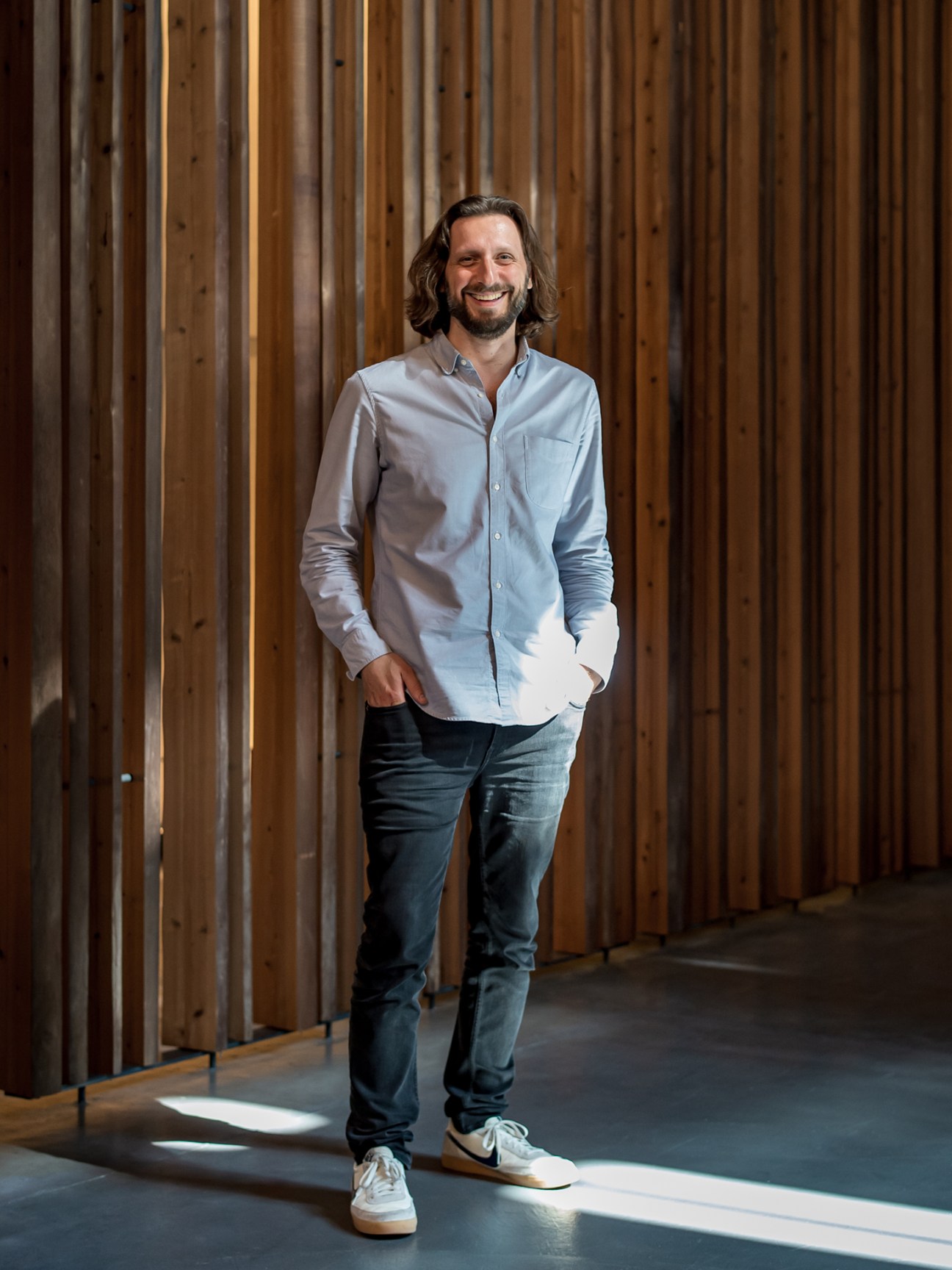 General manager Nico Black standing in a modern hotel corridor with wooden slat walls