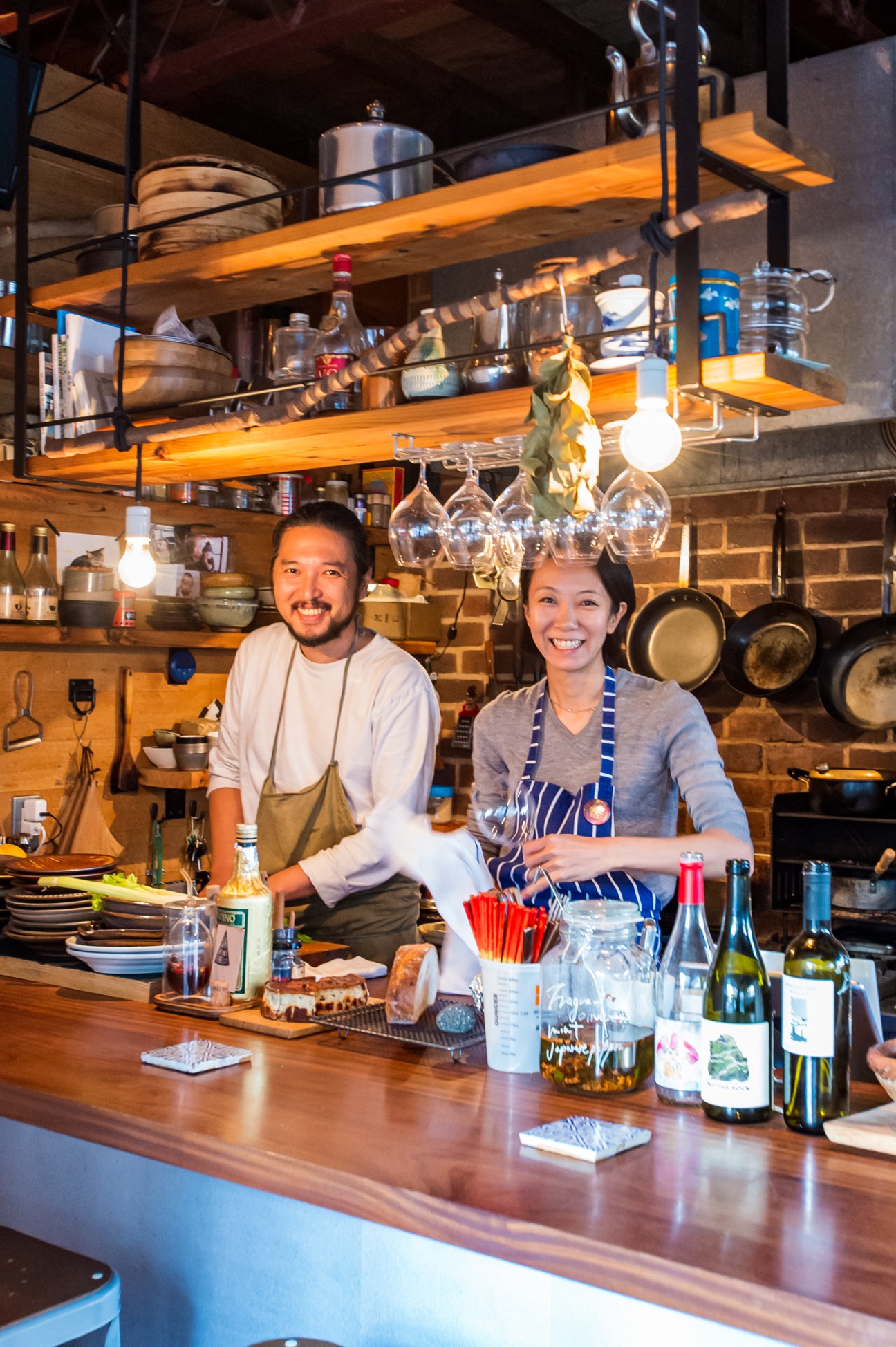 Kenta and Maki Hayashi smiling behind the counter at Hay Grill & Coffee restaurant kitchen