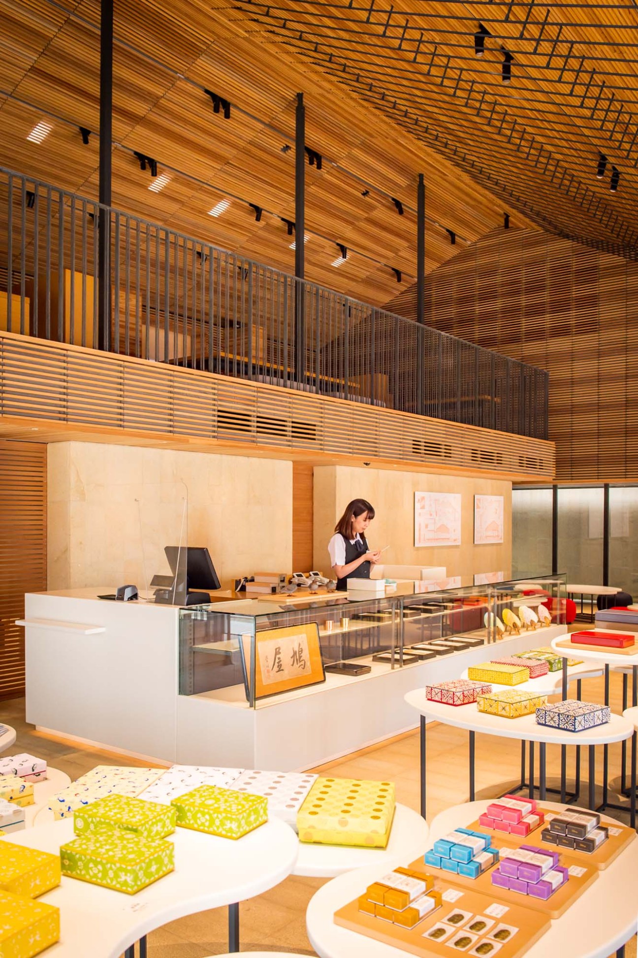 Interior of Kyukyodo stationery shop designed by Hiroshi Naito featuring wooden ceiling, glass display counter and colorful product displays