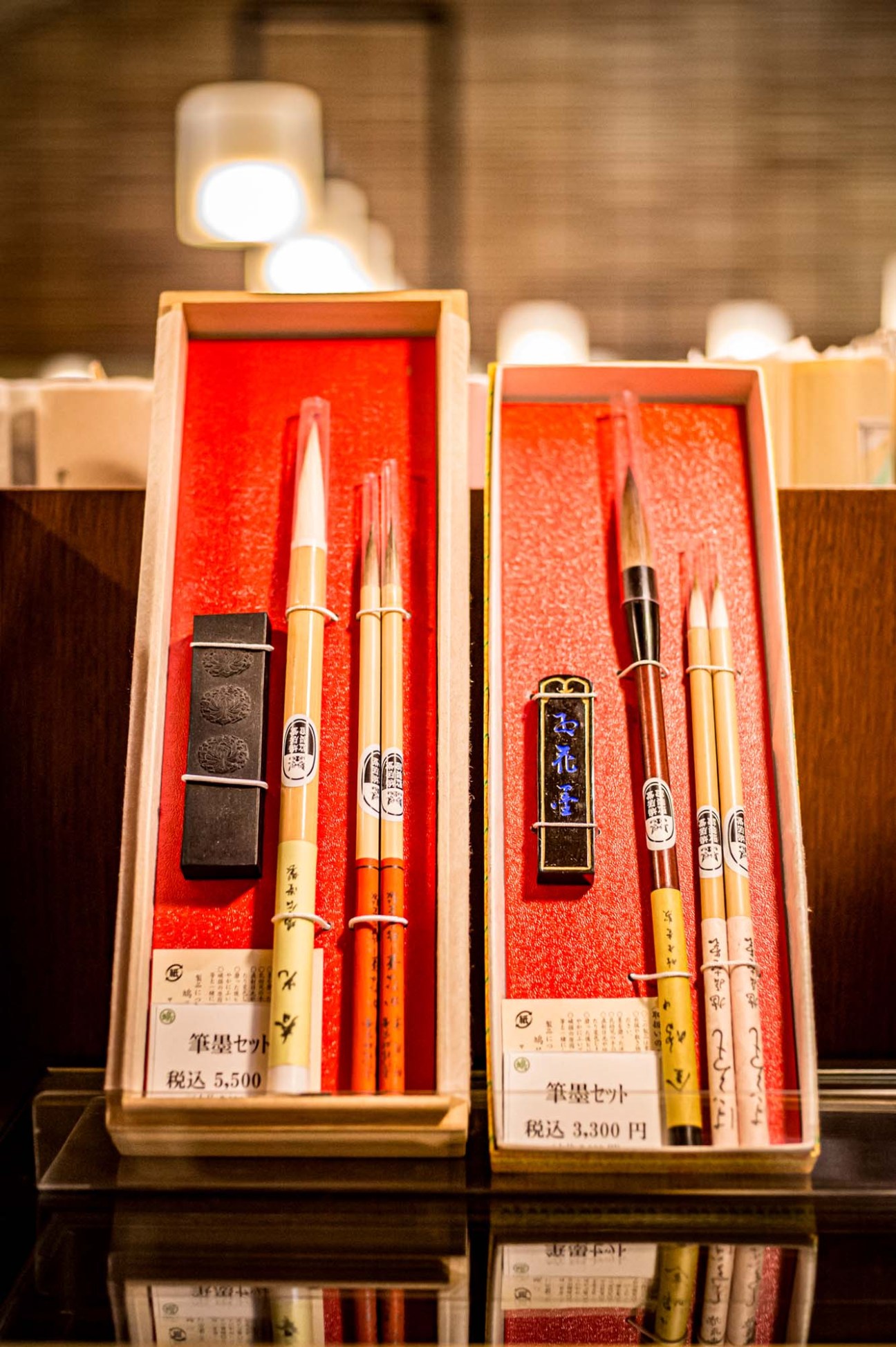 Close-up of traditional Japanese calligraphy sets featuring brushes and sumi ink blocks displayed on wooden surface