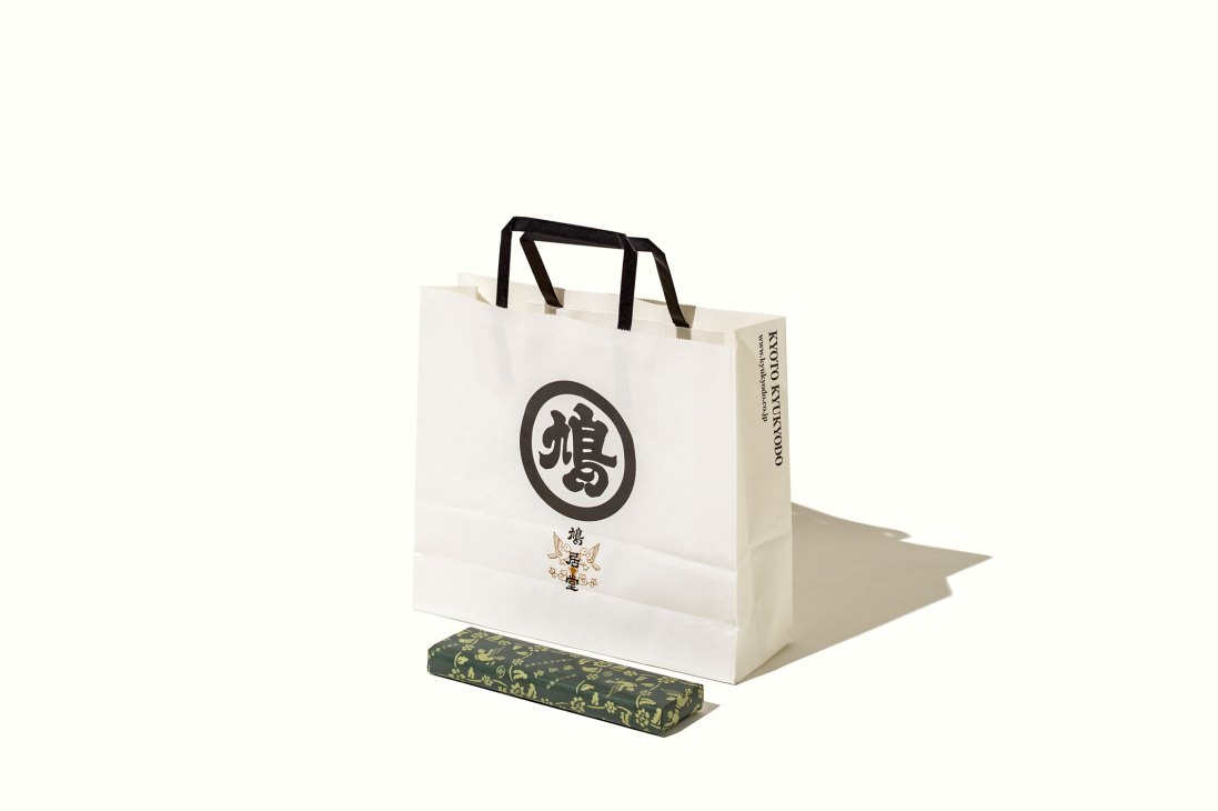 Kyukyodo shopping bag designed by Taku Satoh with minimalist typography and black handles