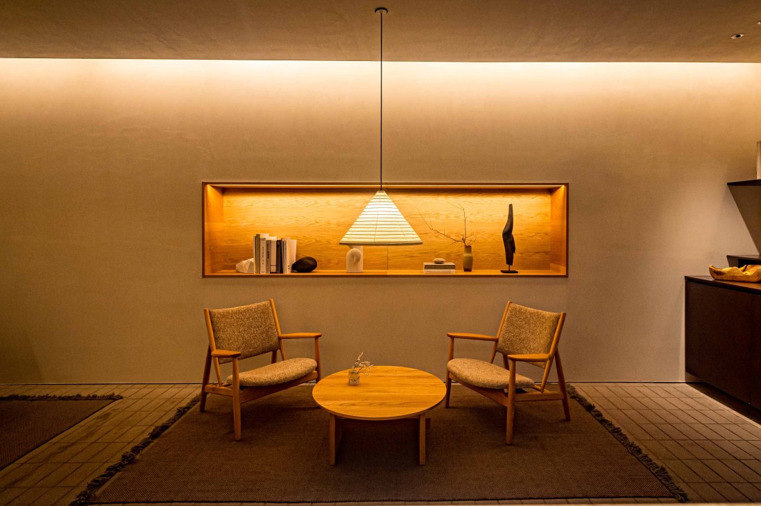 Minimalist hotel guest room with neutral tones, natural textures and large windows