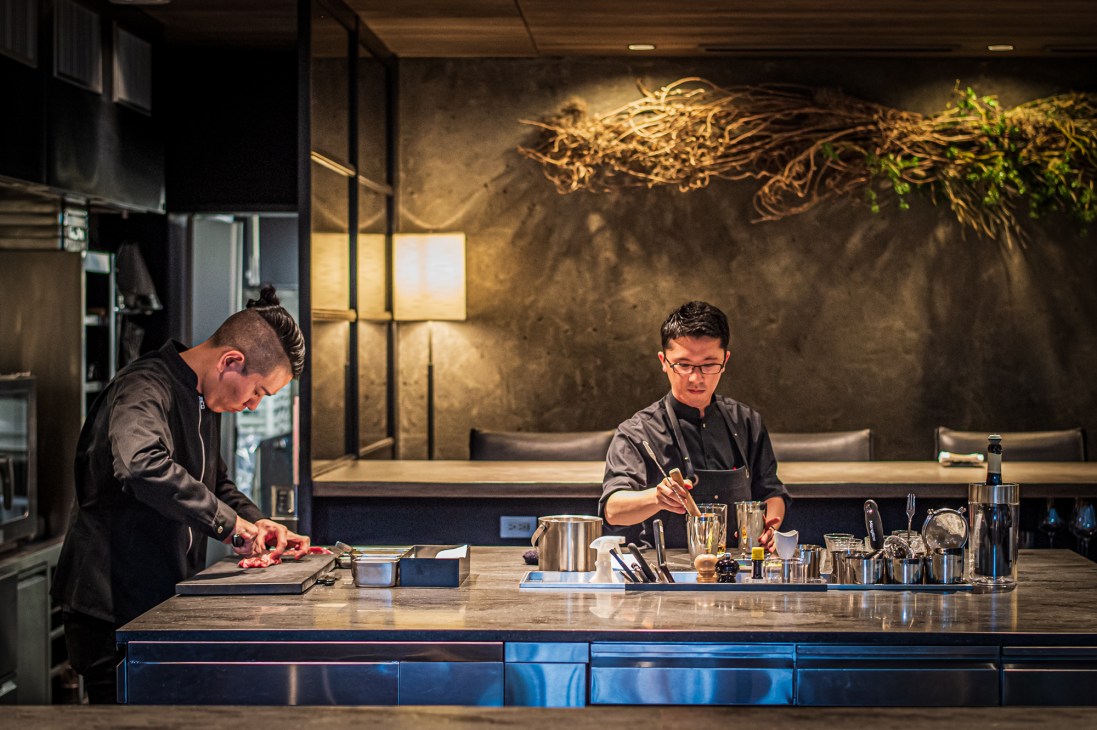 Two chefs working in a modern restaurant kitchen with stainless steel equipment