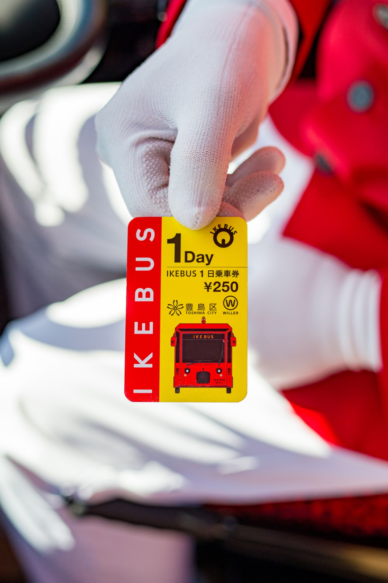 Hand holding an Ike Bus one-day pass ticket for Kamaishi, Japan.