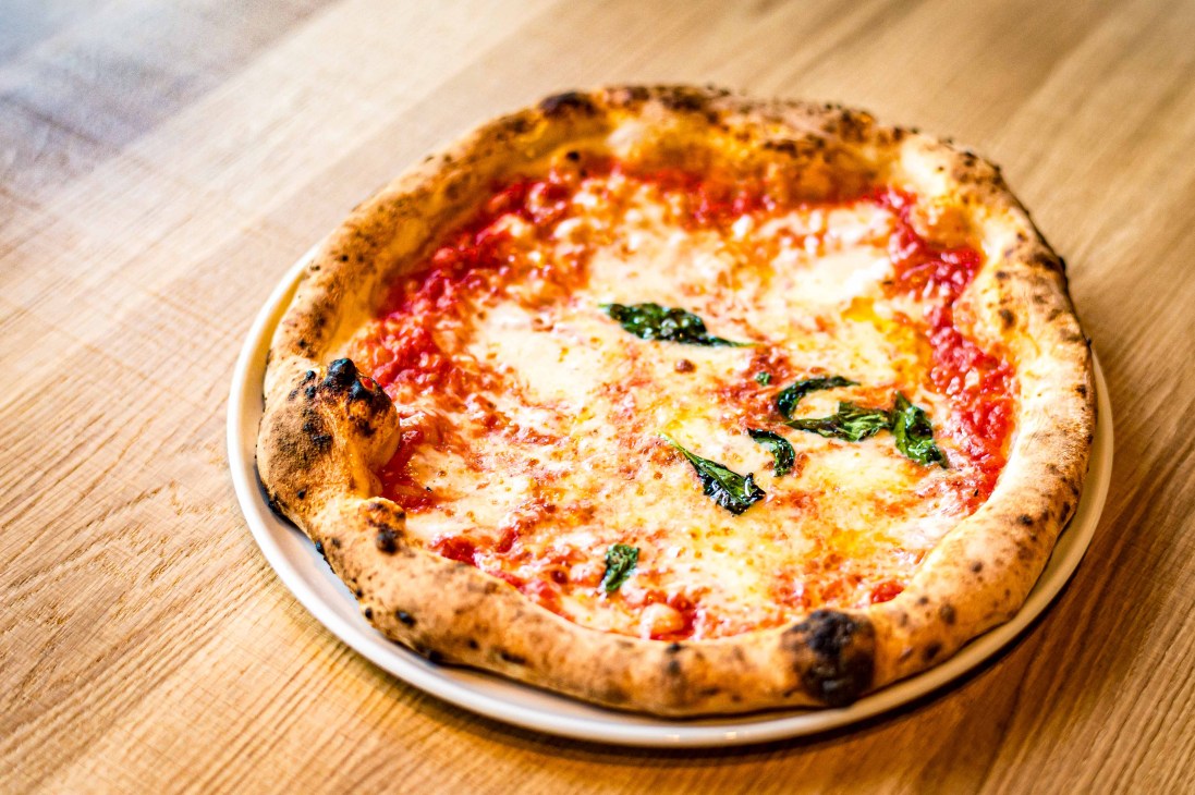 Close-up of a wood-fired pizza oven with flames visible inside