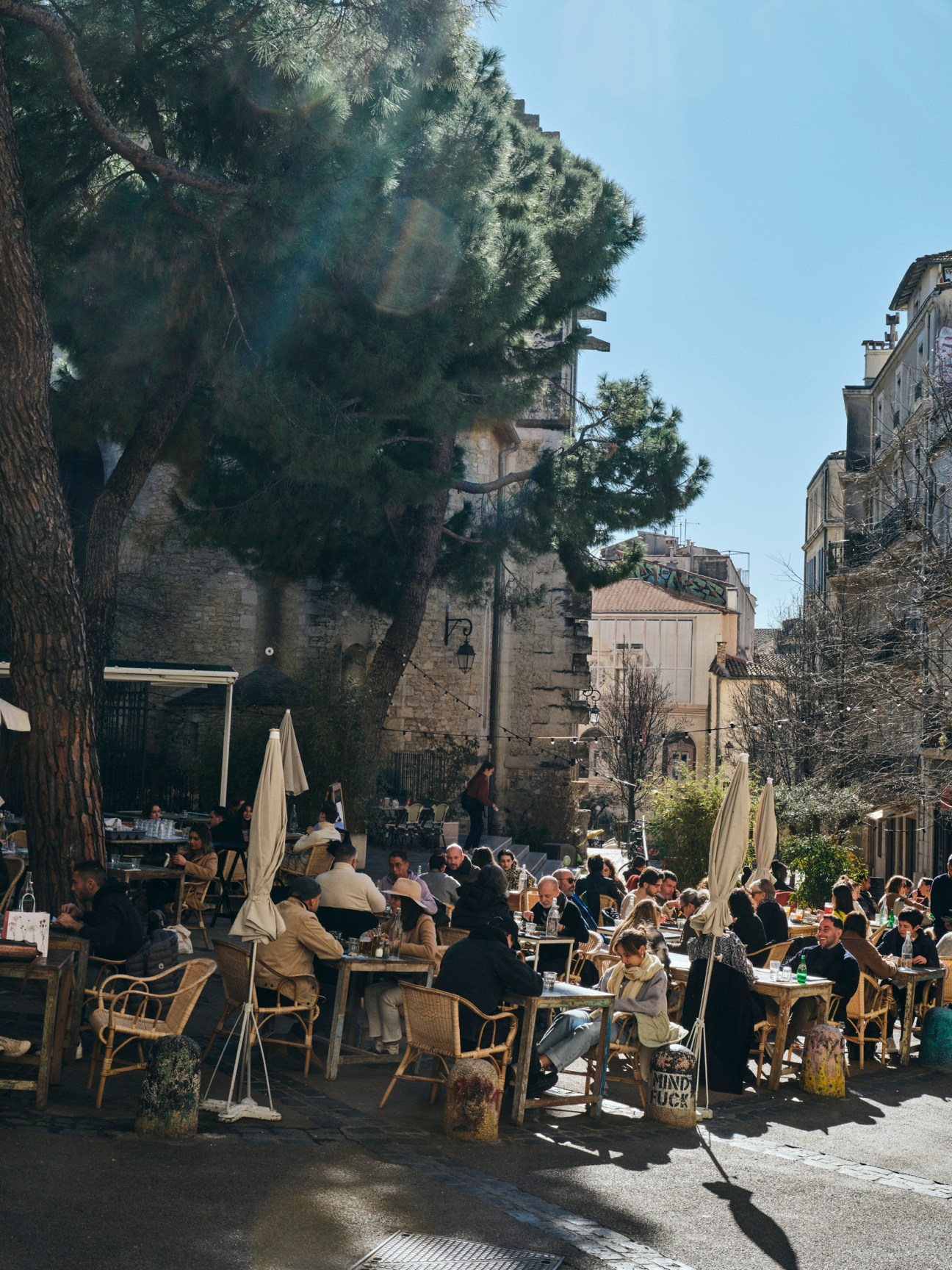 Outdoor café scene in Montpellier old town with people sitting at street-side tables