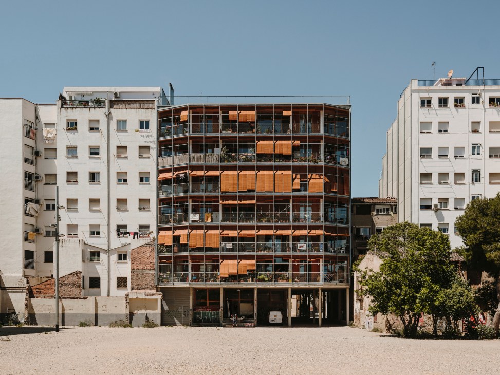 La Borda apartment building in Barcelona with wooden alicantina blinds covering the façade and balconies.