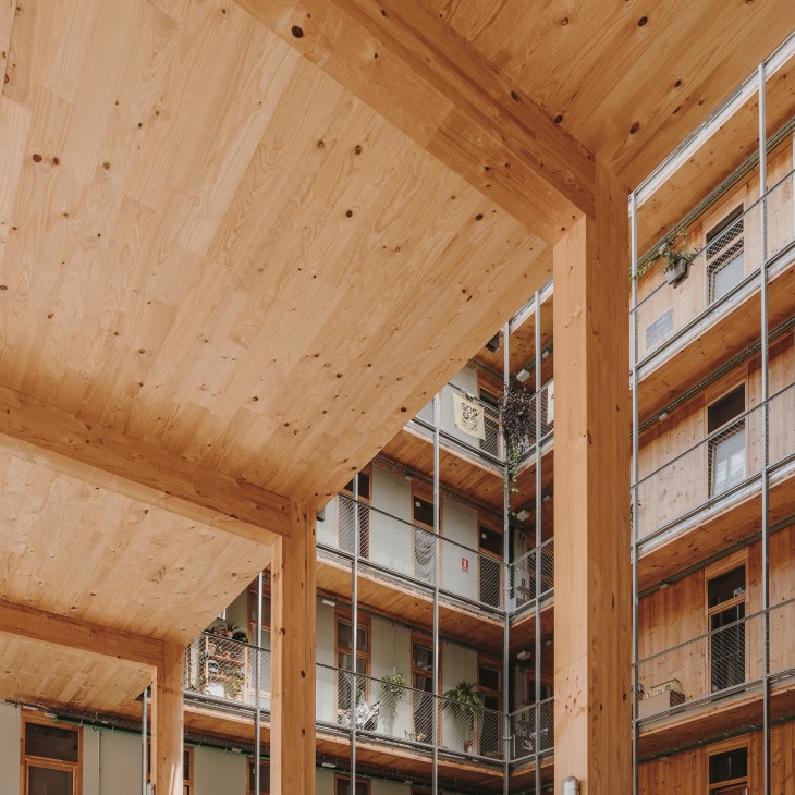 La Borda's wooden interior courtyard with timber beams and balconies with metal railings.