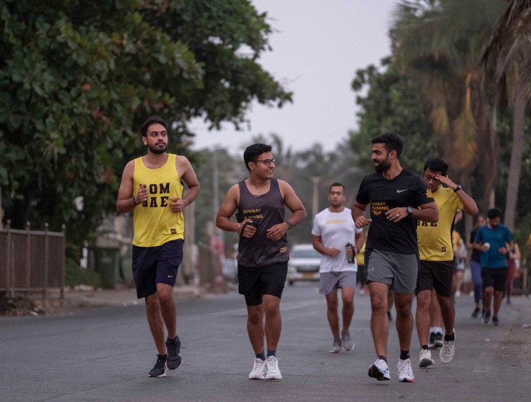 Group of runners jogging together on a tree-lined street in Mumbai