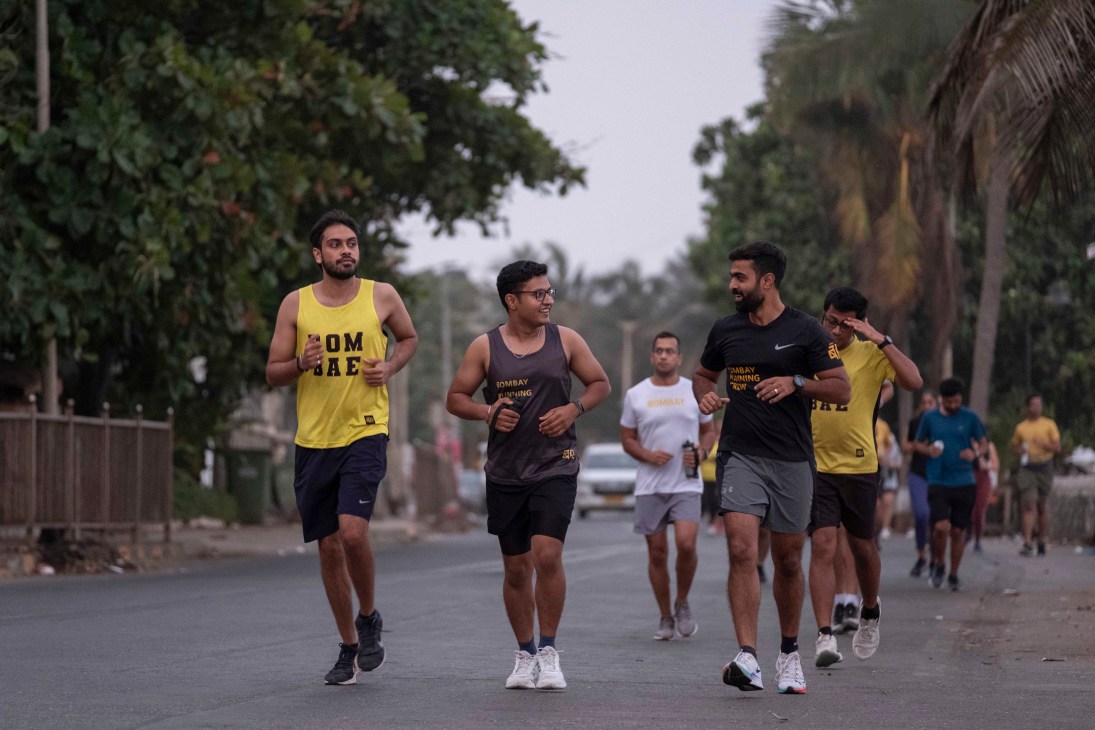Group of runners jogging together on a tree-lined street in Mumbai