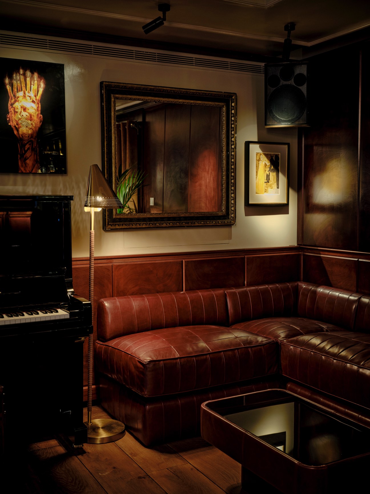 Custom brown leather sofa with tufted upholstery in a warm, dimly lit interior setting