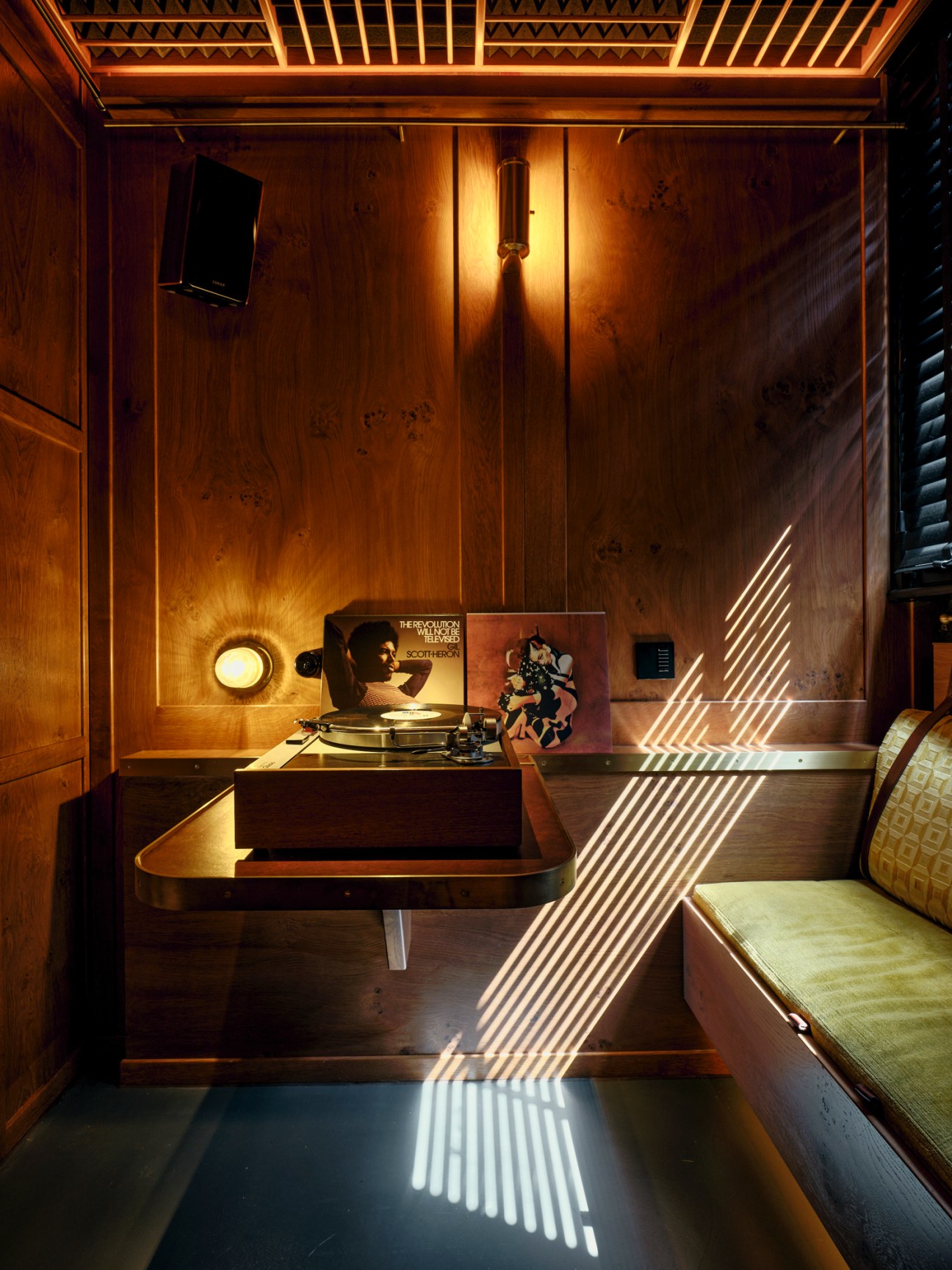 Intimate private booth with curved seating and built-in audio equipment for listening sessions