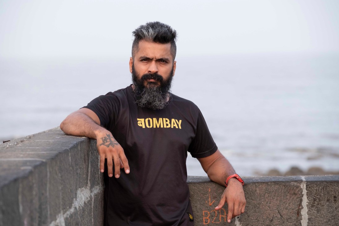 Deepak Oberoi, co-founder of Bombay Running, standing by a concrete barrier near the ocean in Mumbai