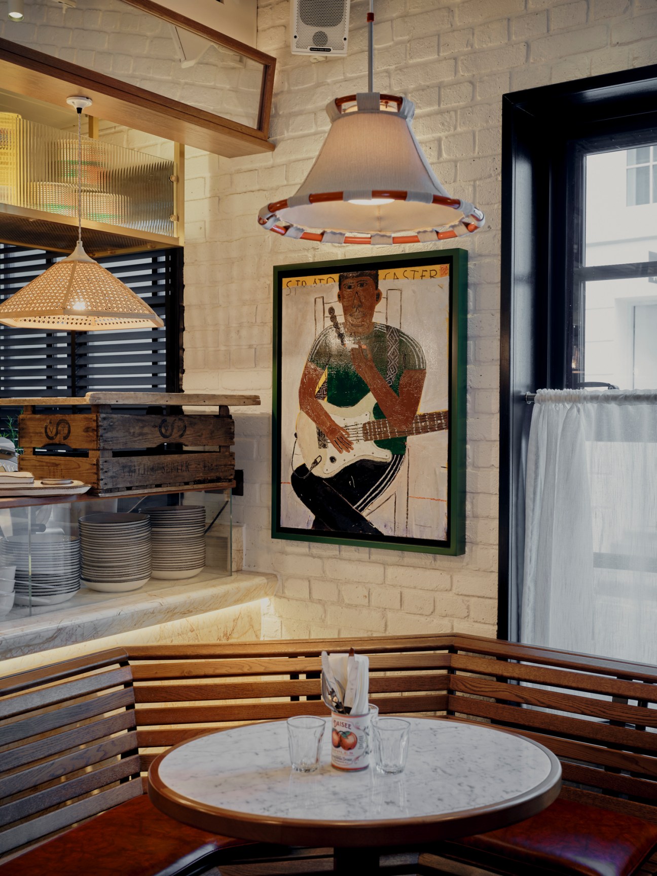 Artwork display showing framed pieces on a wall in an interior setting with ambient lighting