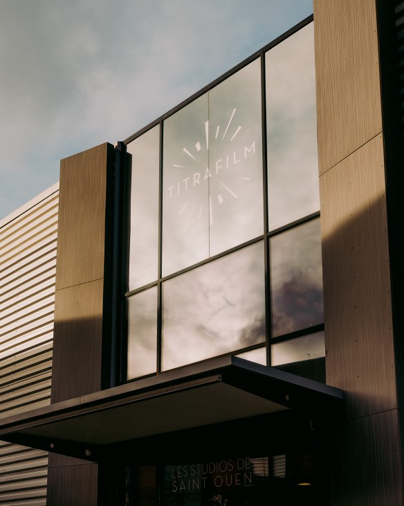 Titrafilm's modern headquarters building with wood paneling and large windows displaying the company logo in Saint-Ouen.