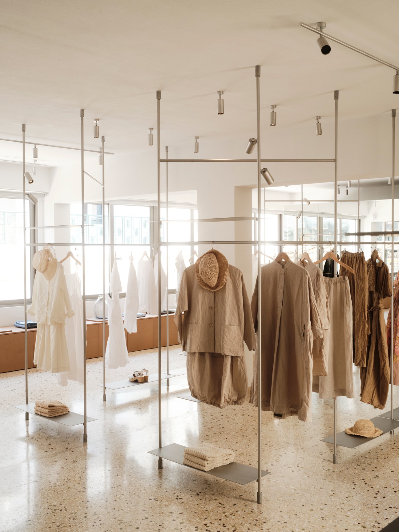 Clothing racks displaying minimal contemporary garments in neutral tones
