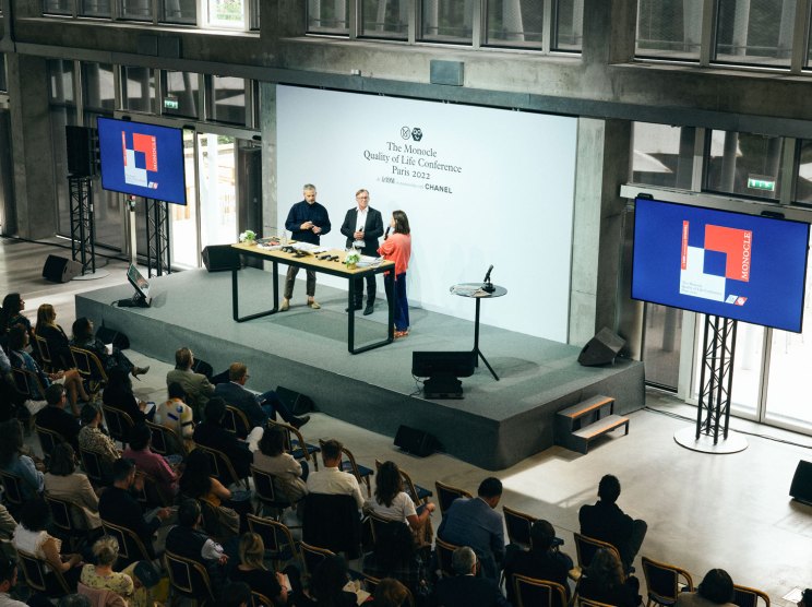 Speakers presenting at Monocle's Quality of Life Conference in Paris with audience seated below