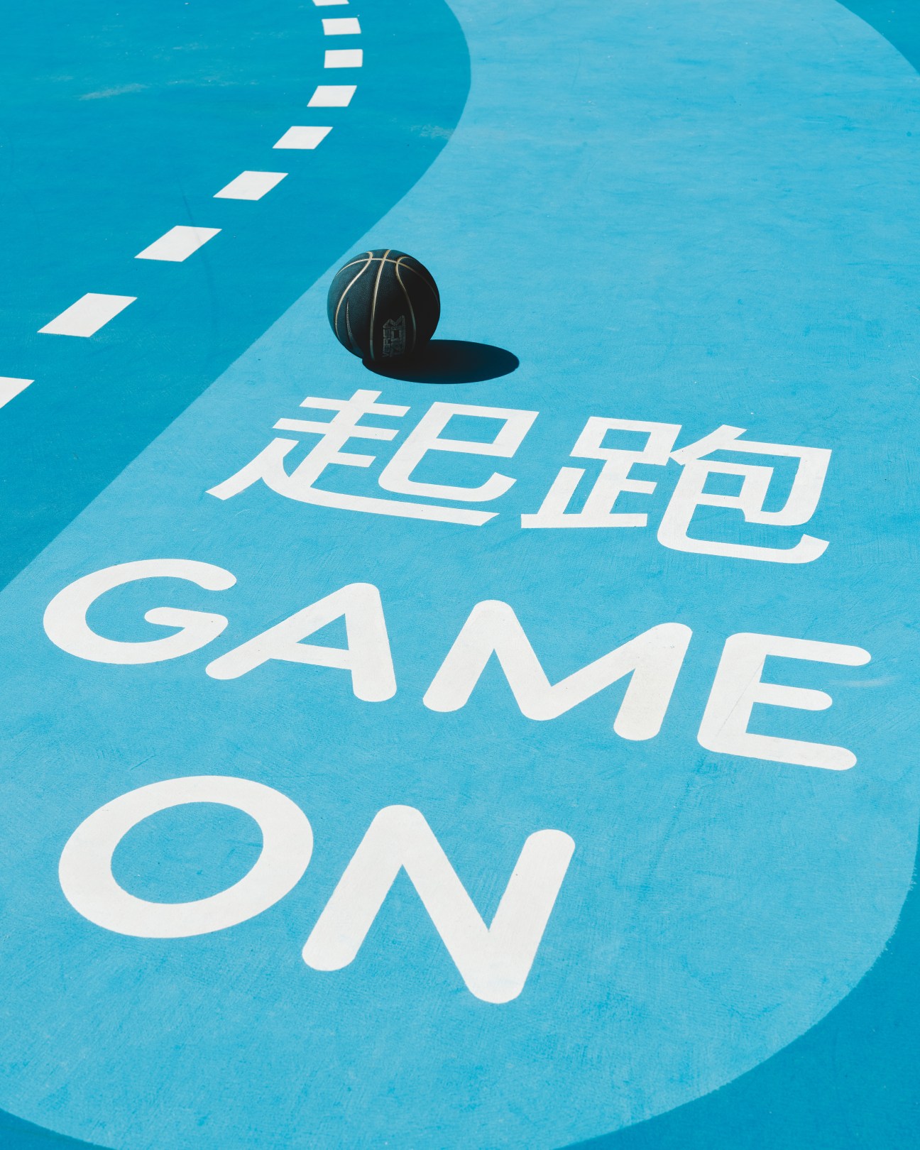 Blue basketball court with white Chinese characters and 'GAME ON' text painted on the surface