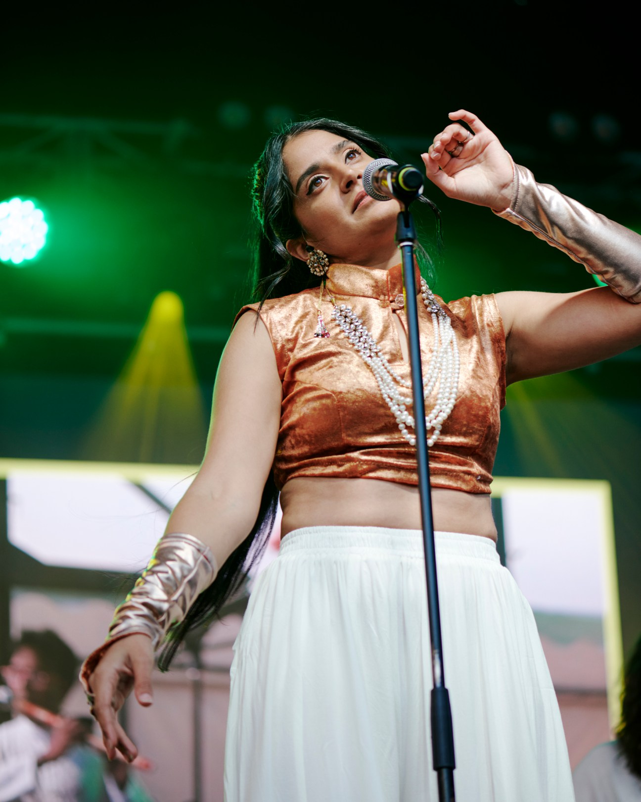 Parvyn performing on stage at Mona Foma festival, singing into microphone with raised hand