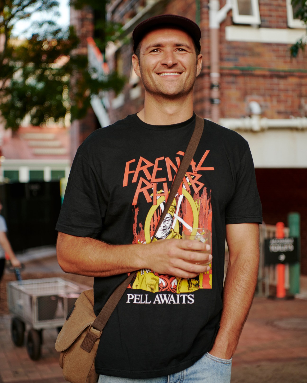 Smiling man in black t-shirt and cap at outdoor festival