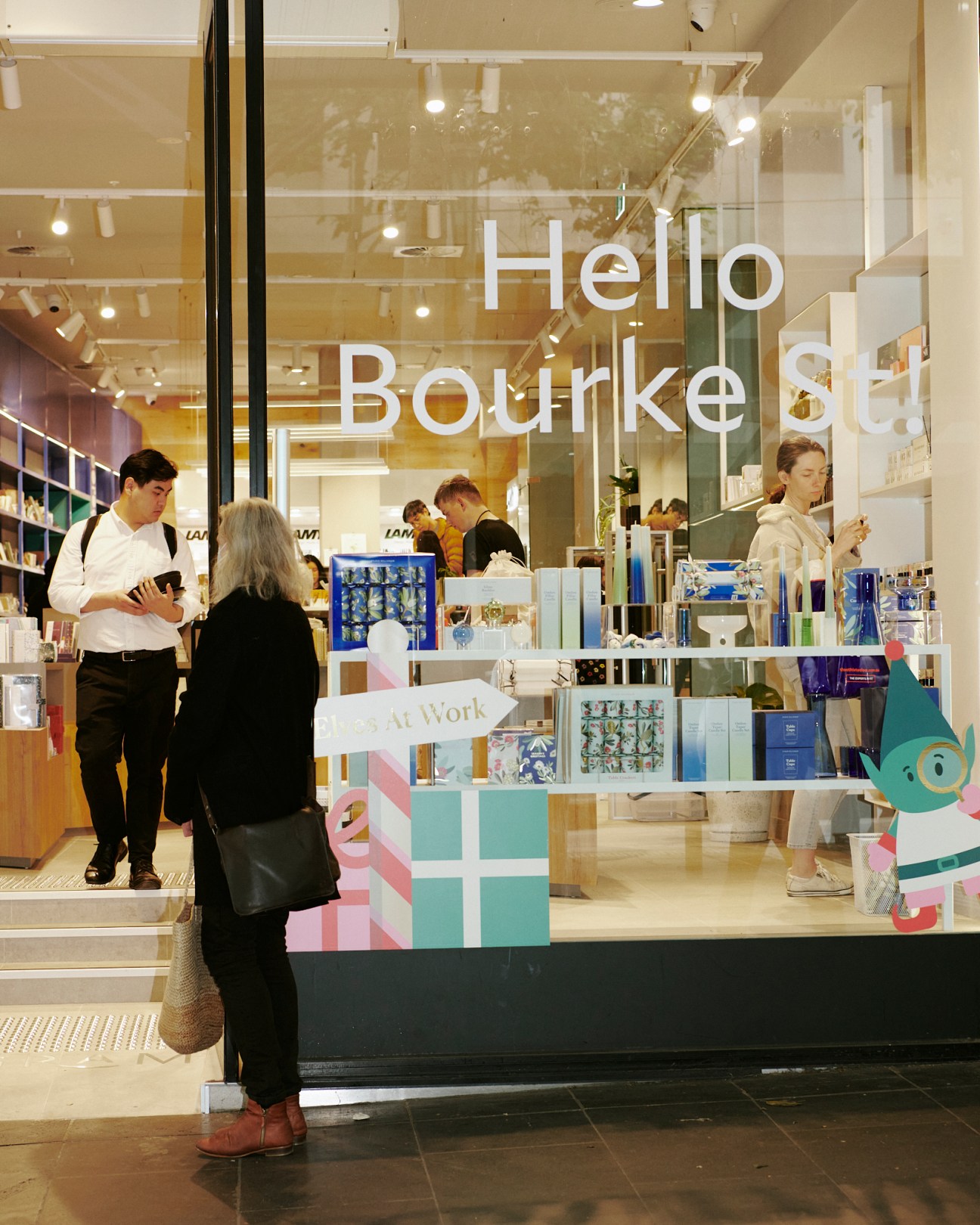 Staff member welcoming customers in Milligram's Melbourne store with powder-blue shelving