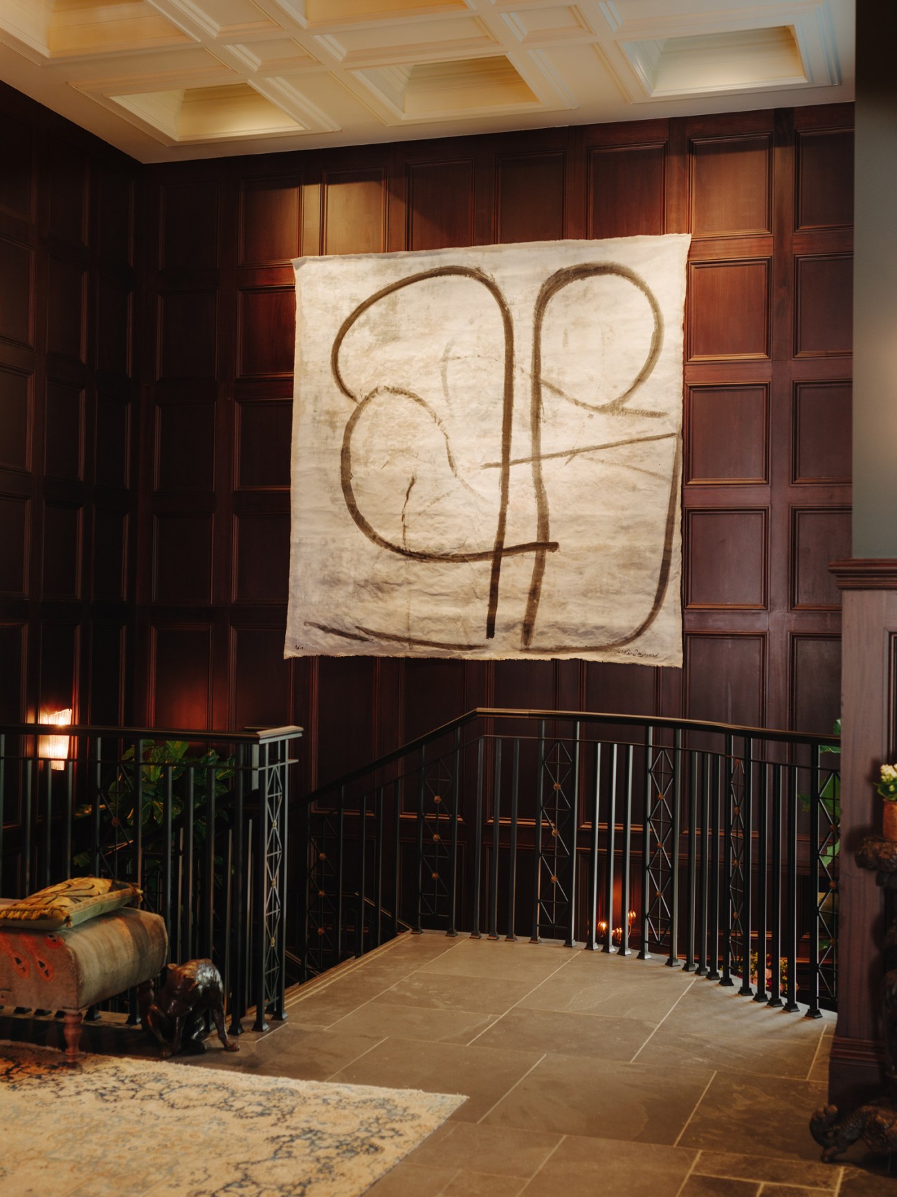 Abstract expressionist painting by Caroline Denervaud hanging in the Nomad hotel's wooden-paneled corridor.