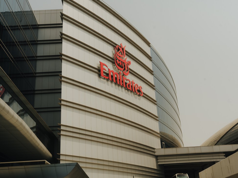 Emirates headquarters building in Dubai with red logo signage on white curved facade.