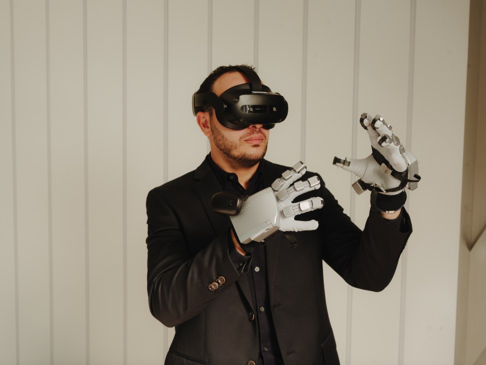Man wearing VR headset and white haptic gloves demonstrates Emirates crew training technology
