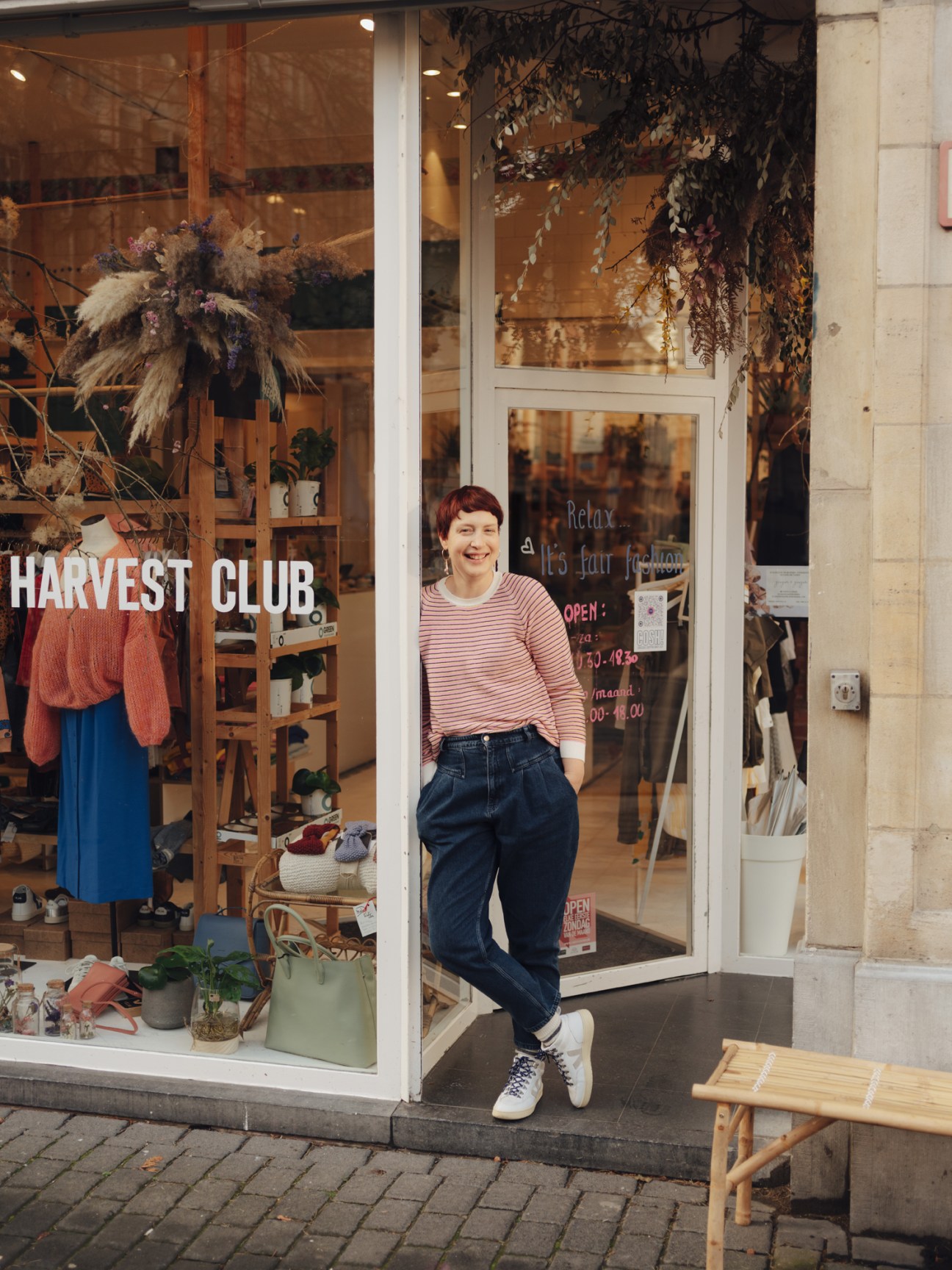 Woman standing in doorway of Harvest Club sustainable shop in Leuven, Belgium