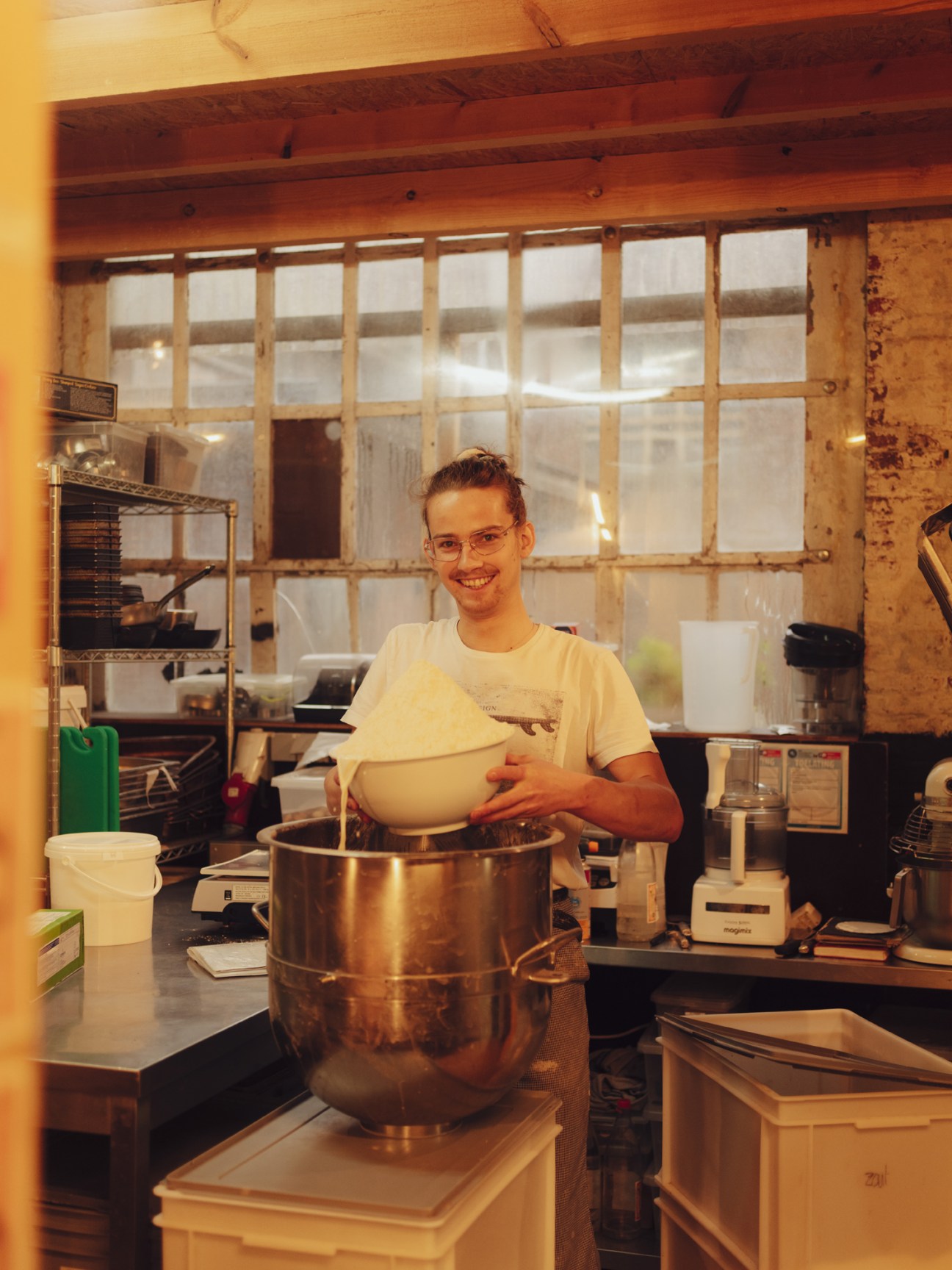 Baker holding fresh bread inside a bakery in Hal 5, Leuven.