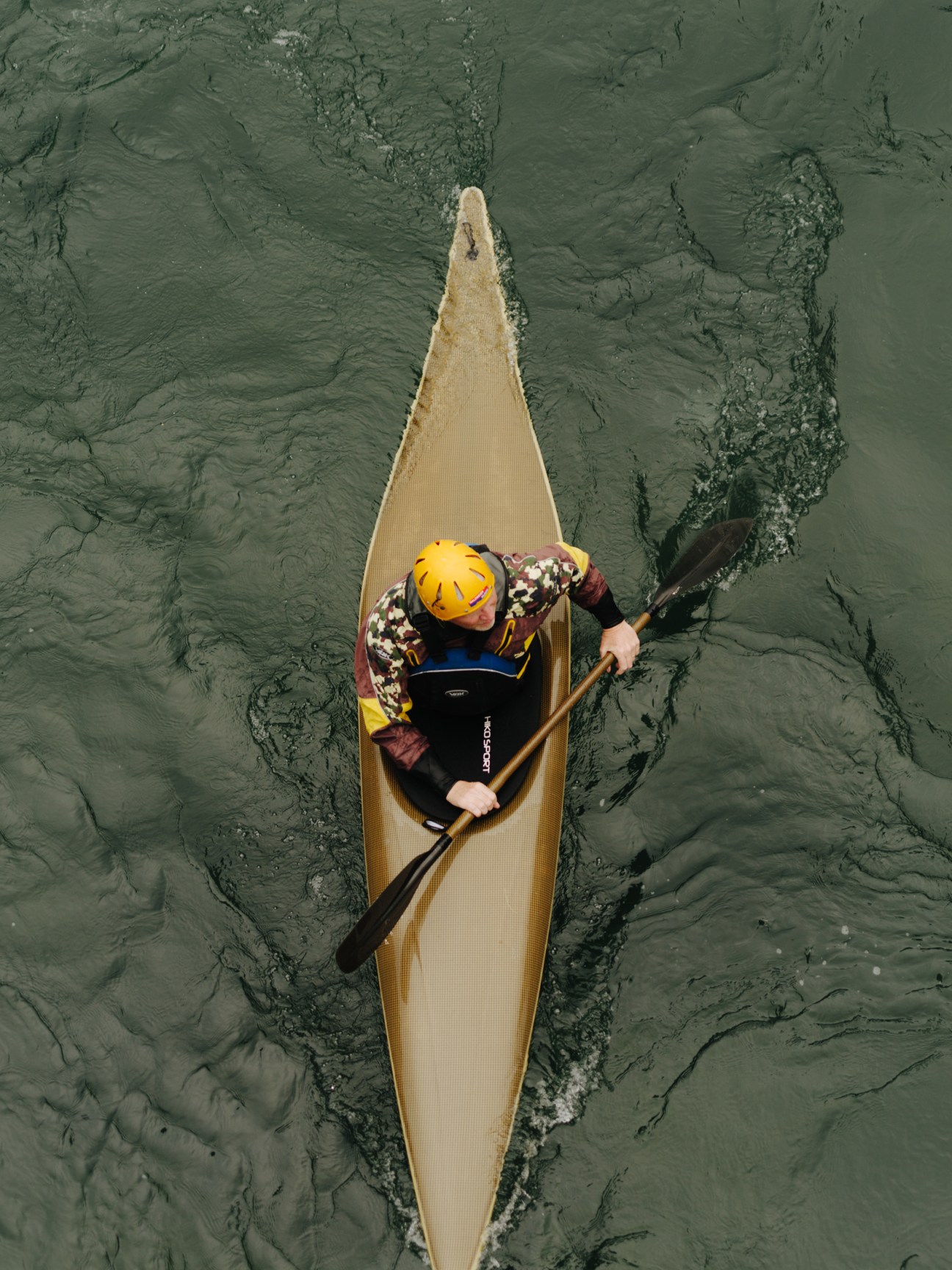 Kayaker paddling on the Limmat river in Baden with townhouses and vegetation visible on the banks