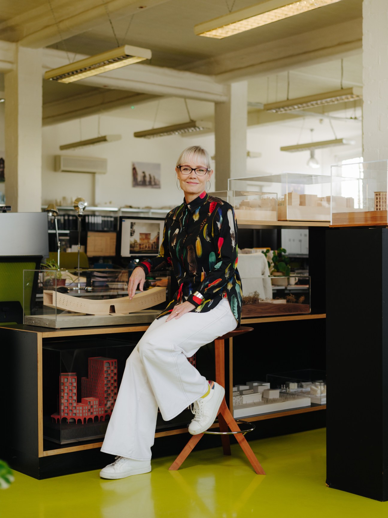 Alison Brooks sitting on a handcrafted cherry wood kitchen stool in her London home