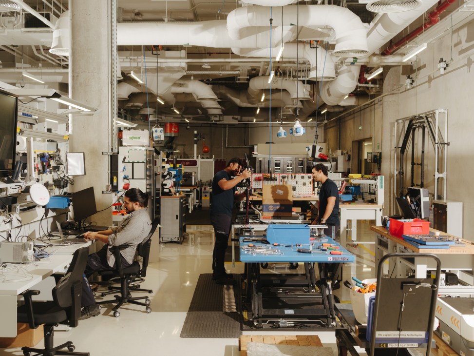 Engineers and researchers working in a modern robotics laboratory with equipment, workstations, and tools at Dubai Future Labs.