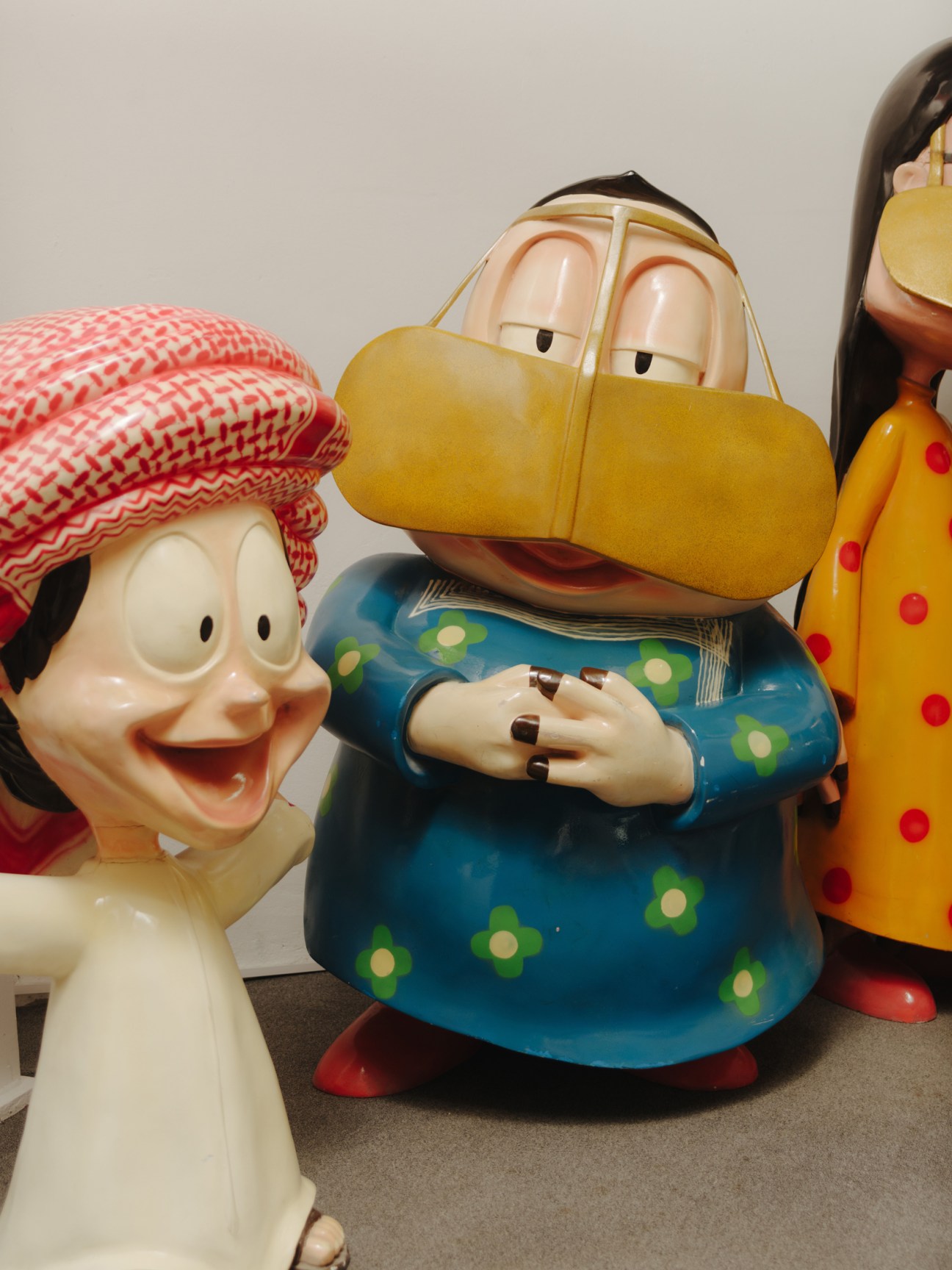 Colorful figurine sculptures of characters from the animated series Freej, featuring exaggerated facial features and traditional clothing.