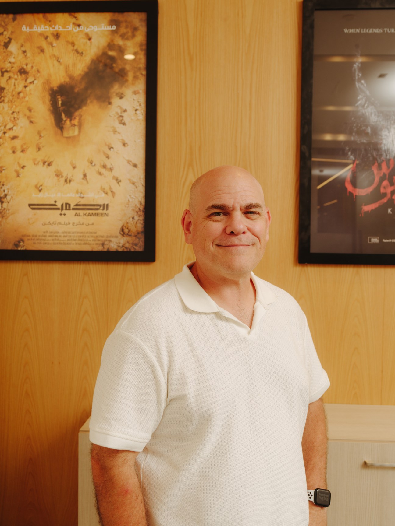 Derek Dauchy, head of content at Image Nation, posing in front of framed film posters in his office.