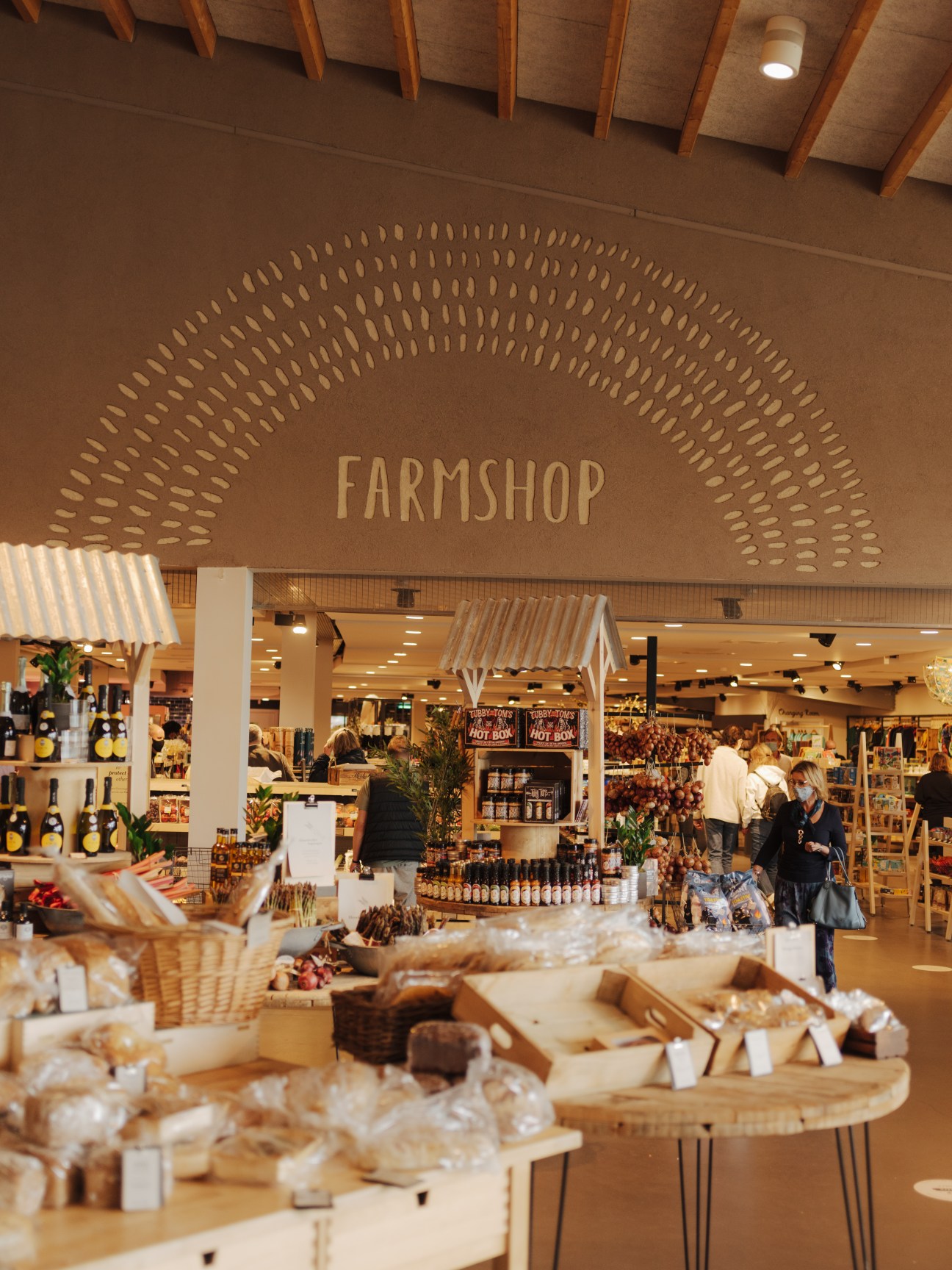 Interior of Gloucester Services farmshop with wooden beams, signage, and shelves of local products.