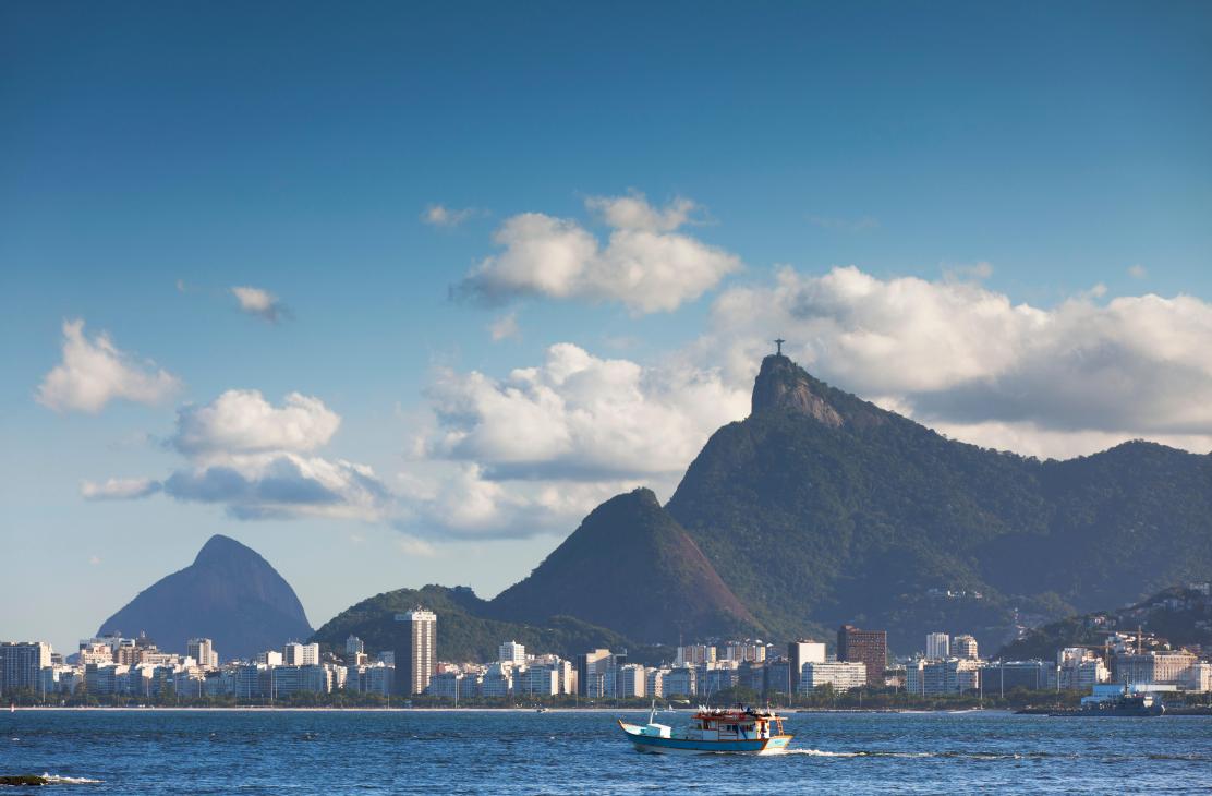 View of Rio de Janeiro showing Christ the Redeemer statue, mountains, cityscape and boat on water