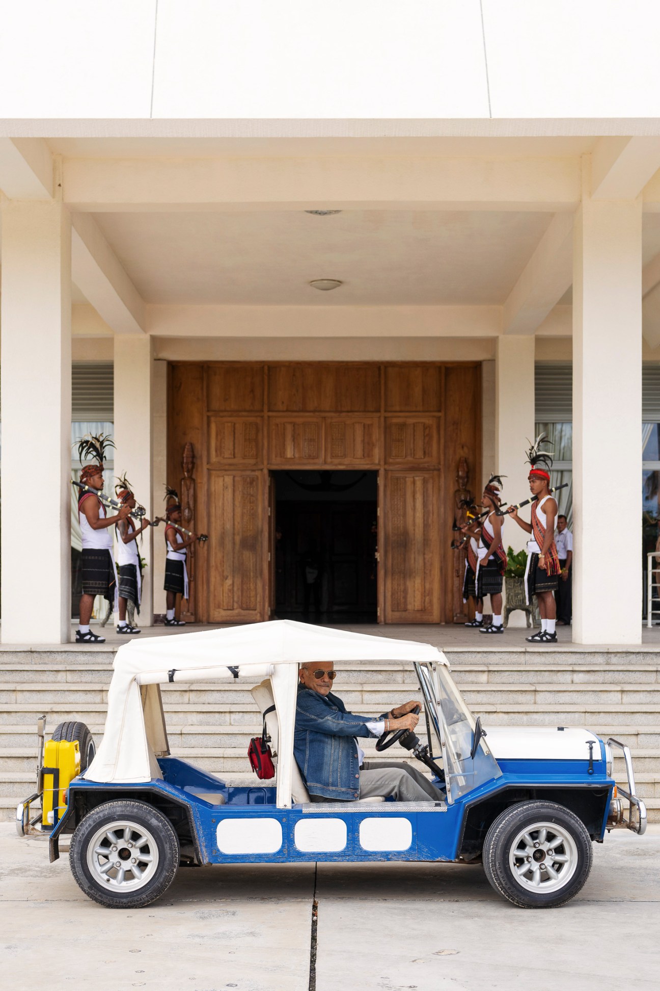 President José Ramos-Horta sits in his bright blue Mini Moke outside the Presidential Palace with traditional guards