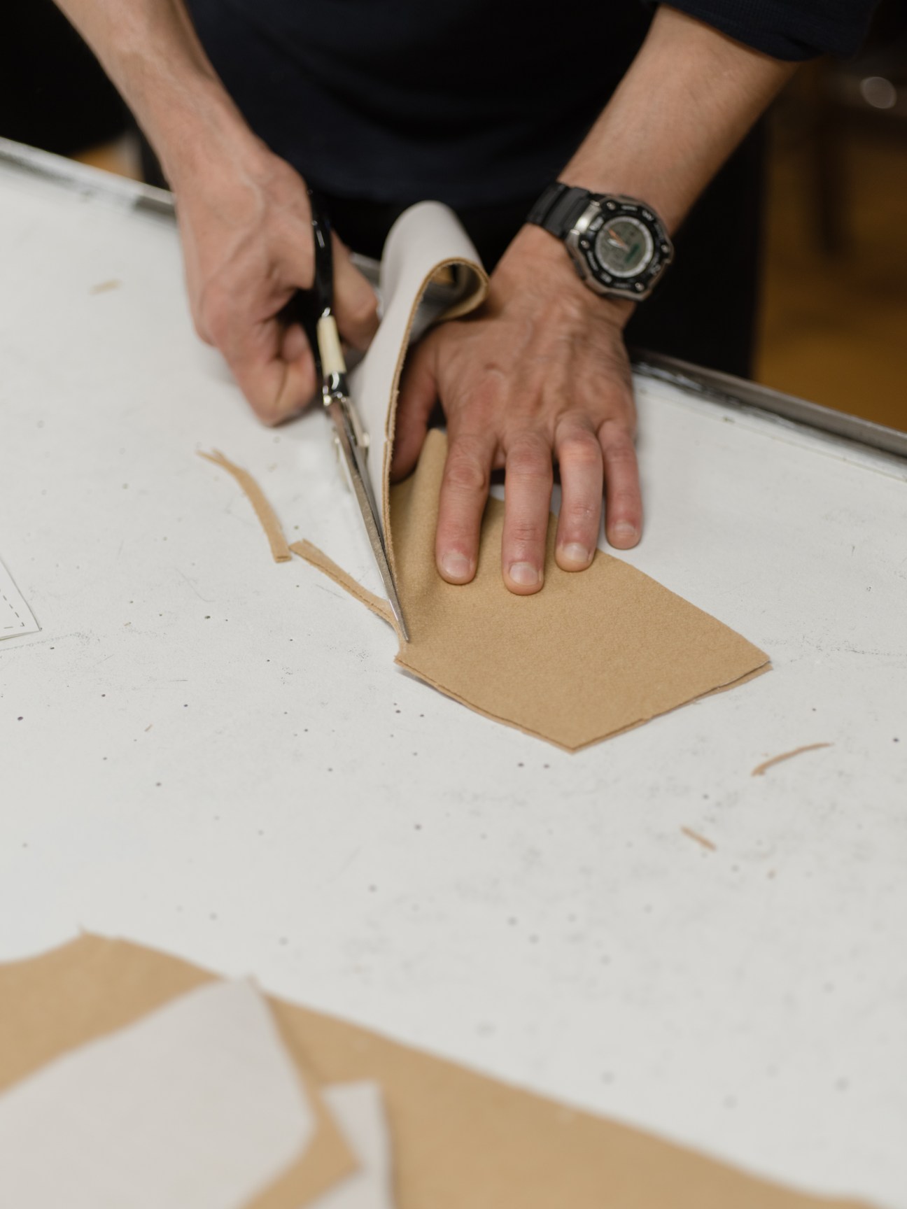 Person cutting tan-colored fabric with scissors at Ecologyst's Victoria manufacturing facility.
