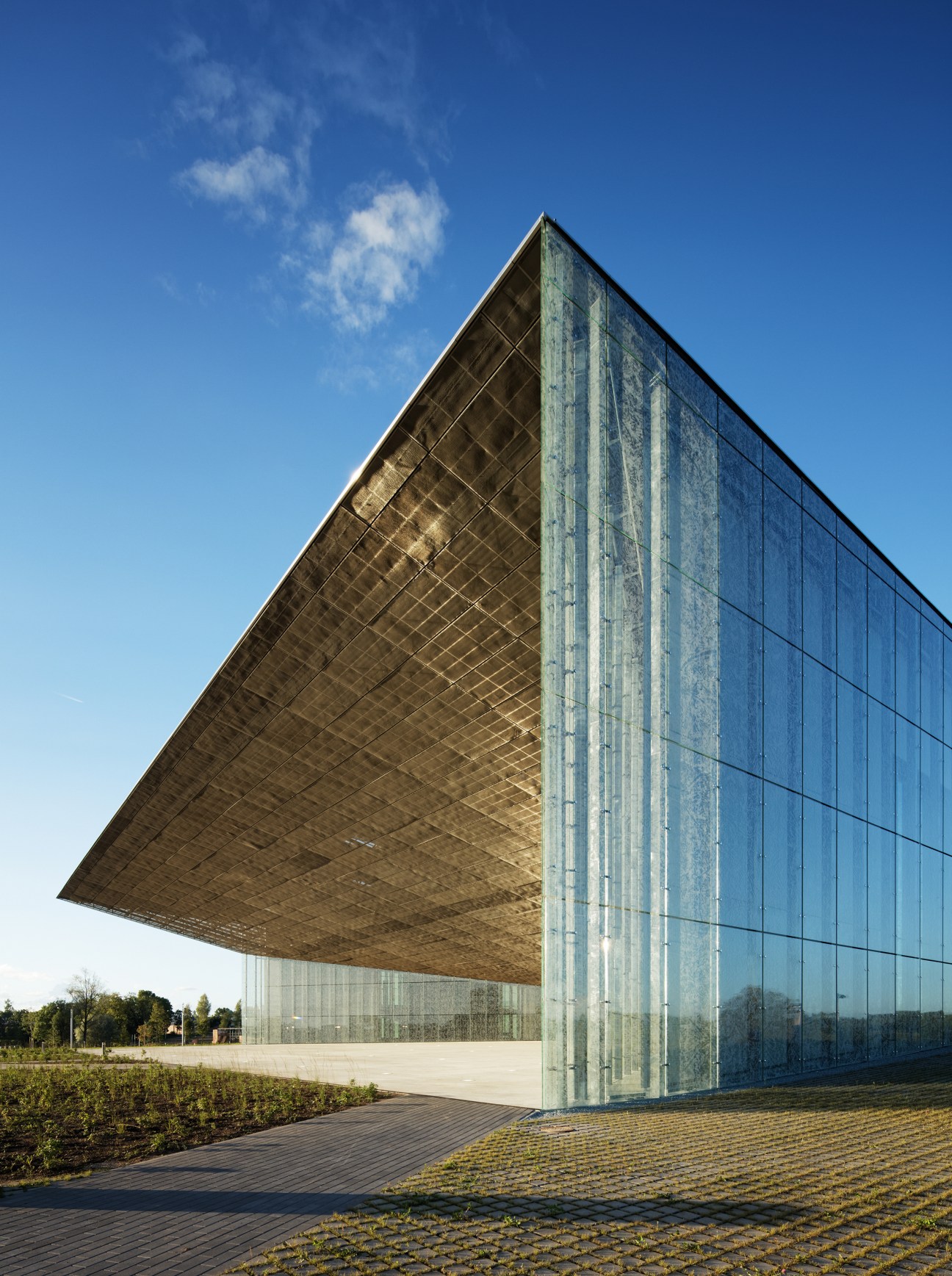 Estonian National Museum building with angular glass facade and dramatic sloping roof against blue sky