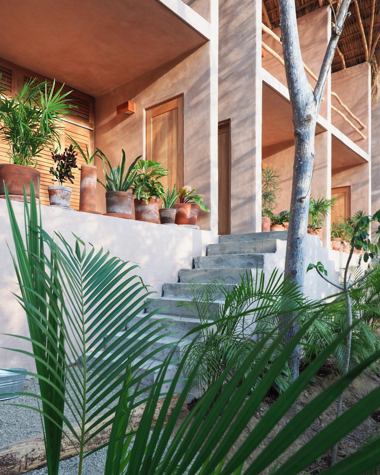 Hotel room interior with exposed wooden beams, natural materials, and eco-friendly design at Monte Uzulu in Oaxaca